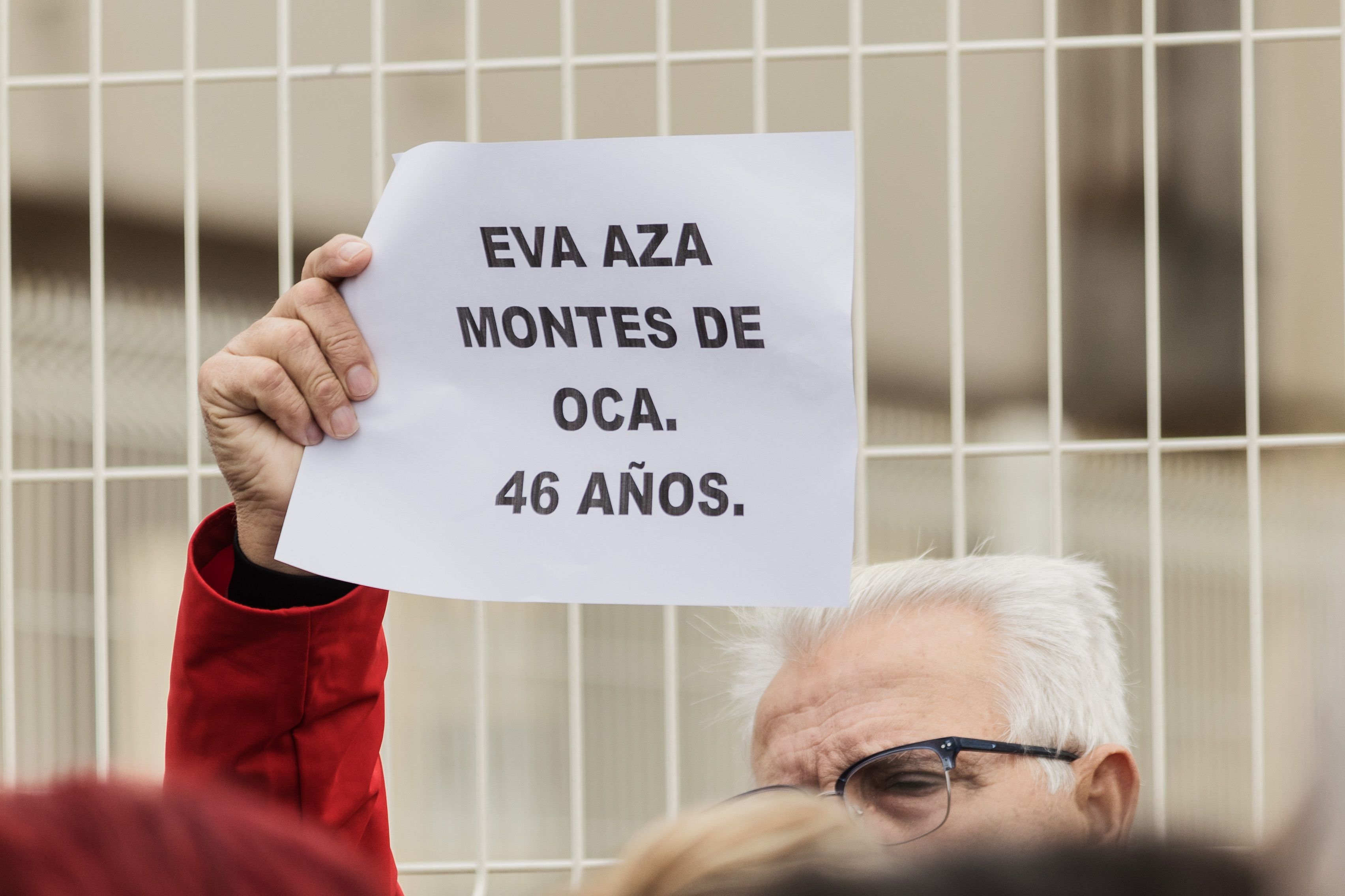 Un hombre sostiene un cartel con el nombre y edad de Eva Aza, víctima de crimen machista. 