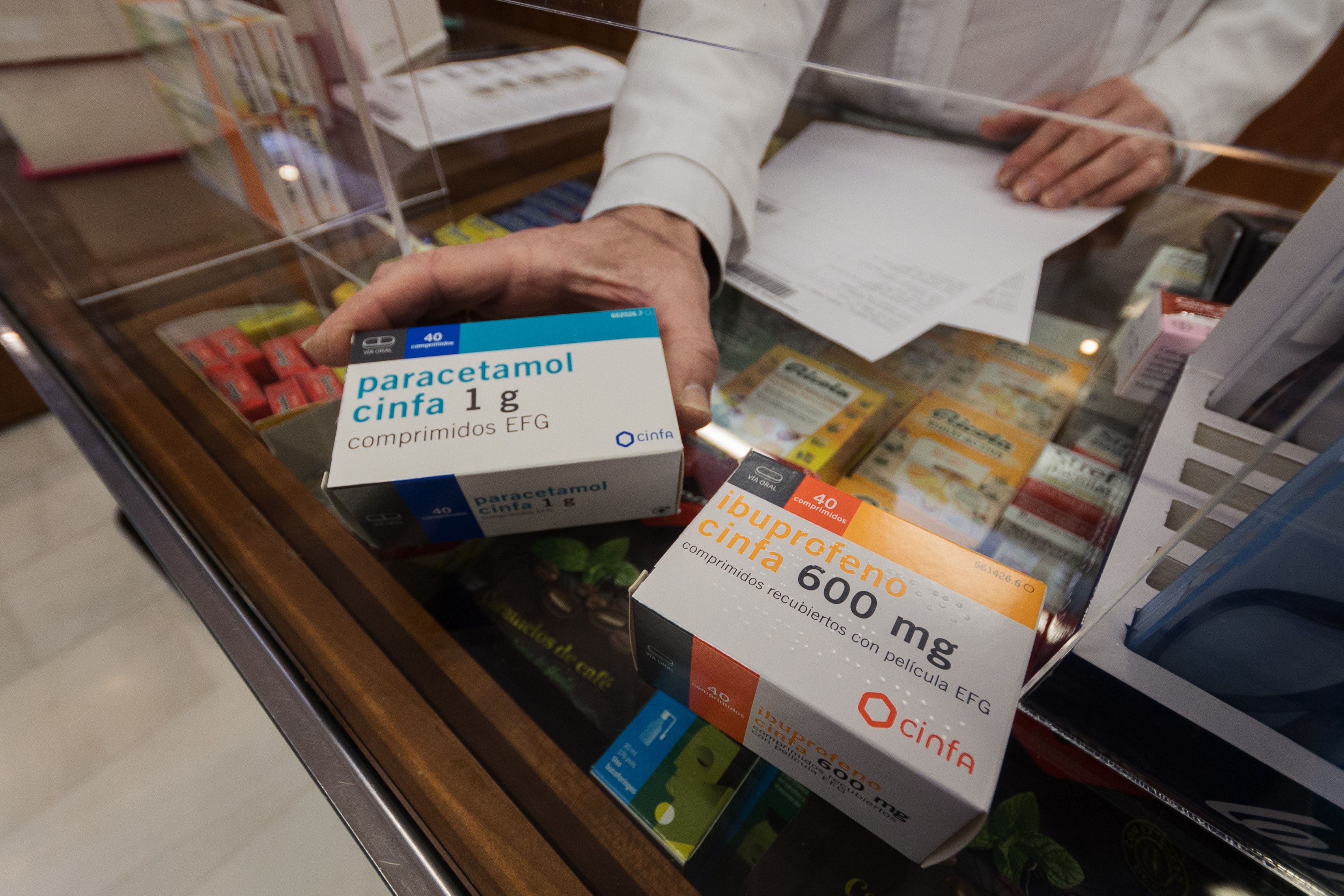 Envases de paracetamol e ibuprofeno dispensados en una farmacia.