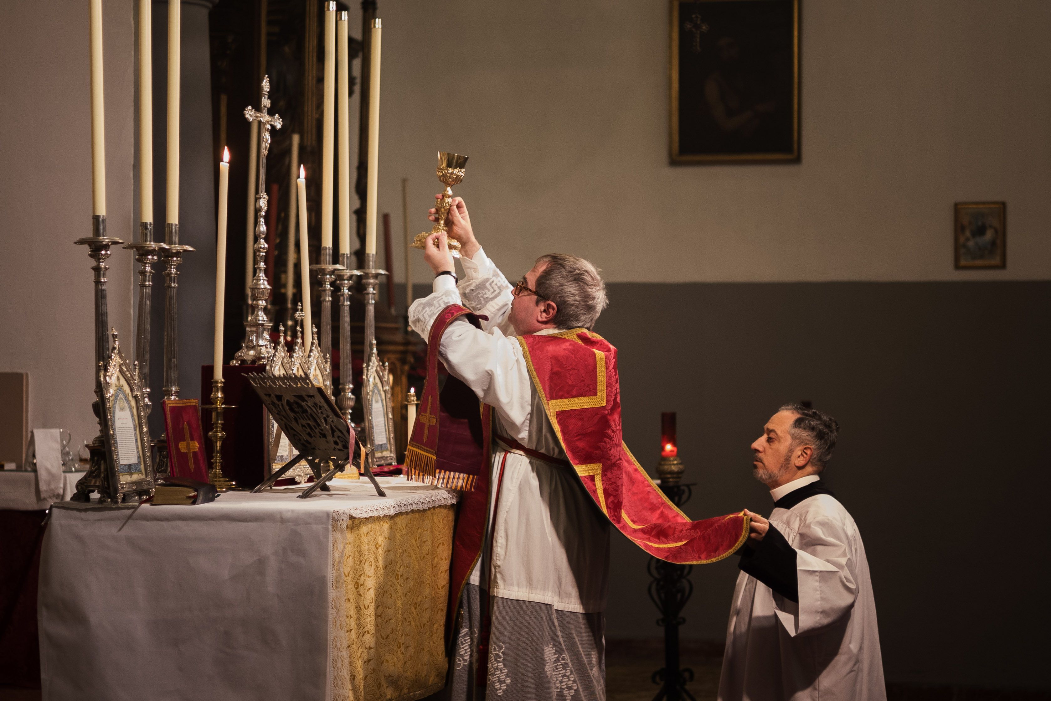 El sacerdote, José Calvin, durante la consagración asistido por un acólito.      MANU GARCÍA