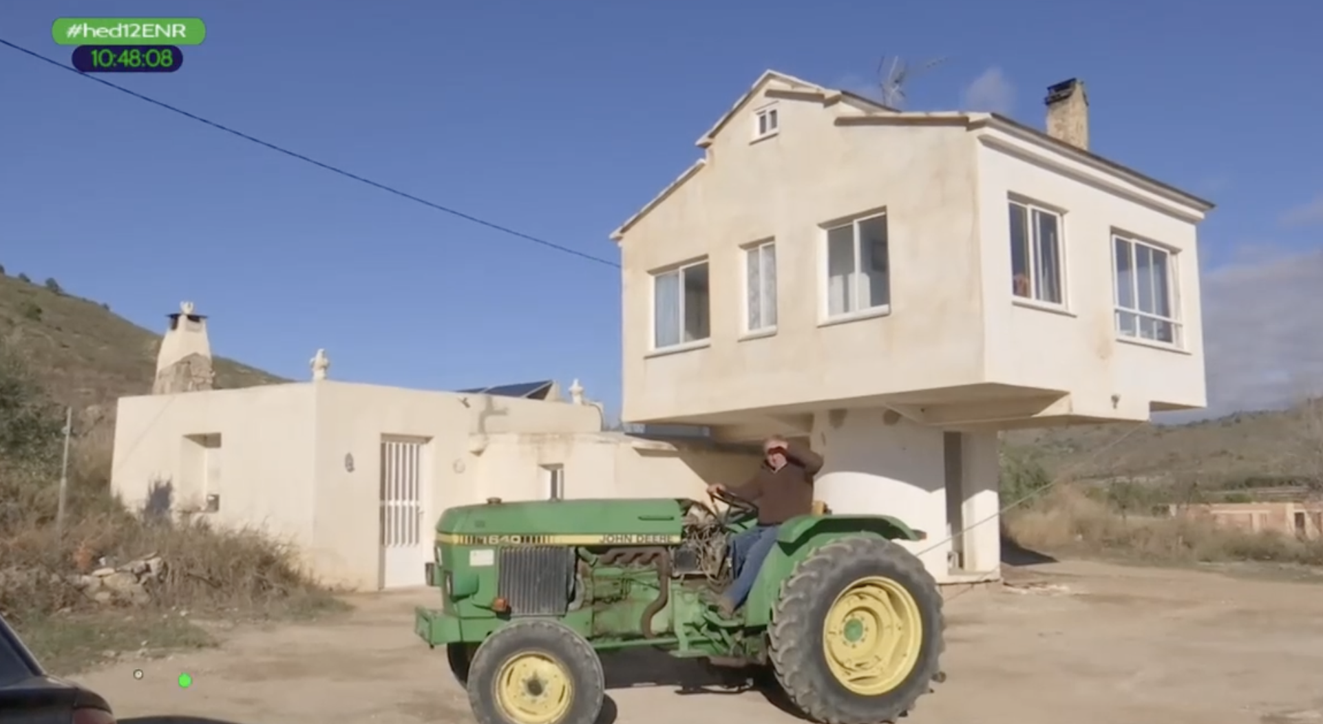 Un albañil levanta una casa giratoria. En la imagen, subido en su tractor ante la casa giratoria que ha construido.