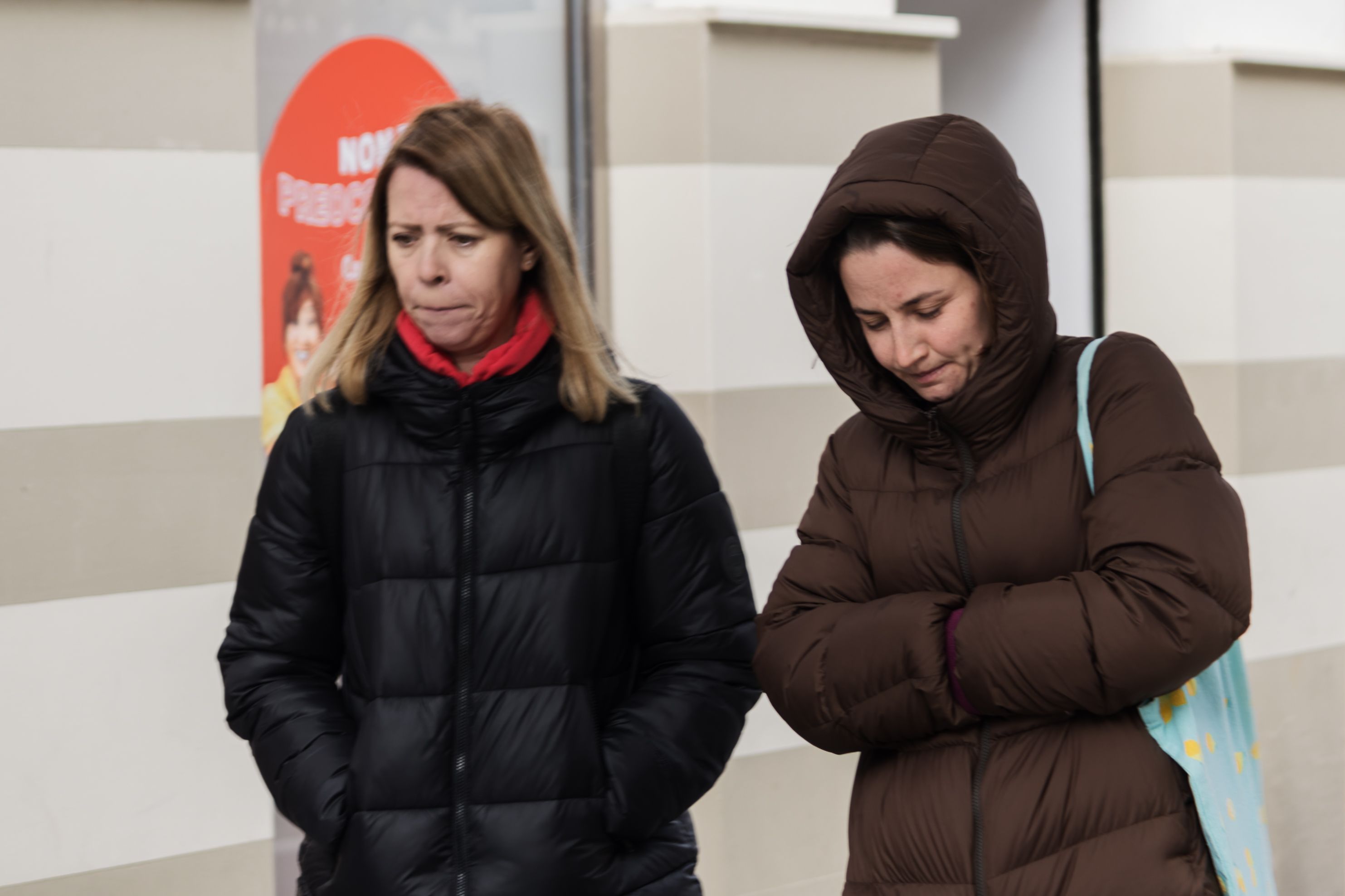 Mujeres paseando por la calle, abrigadas por el frío.