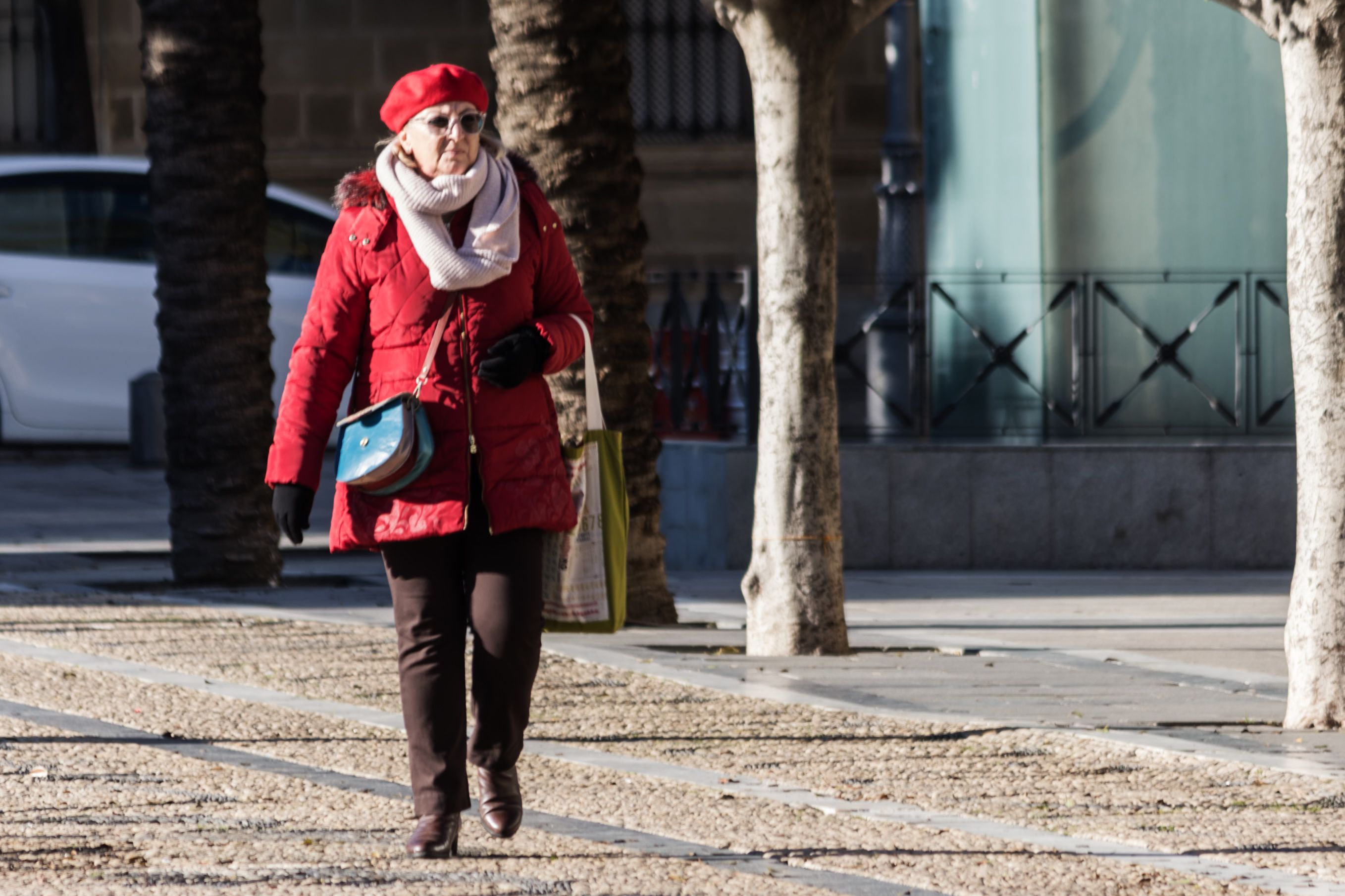 Una mujer muy abrigada pasea por las calles de Jerez. 