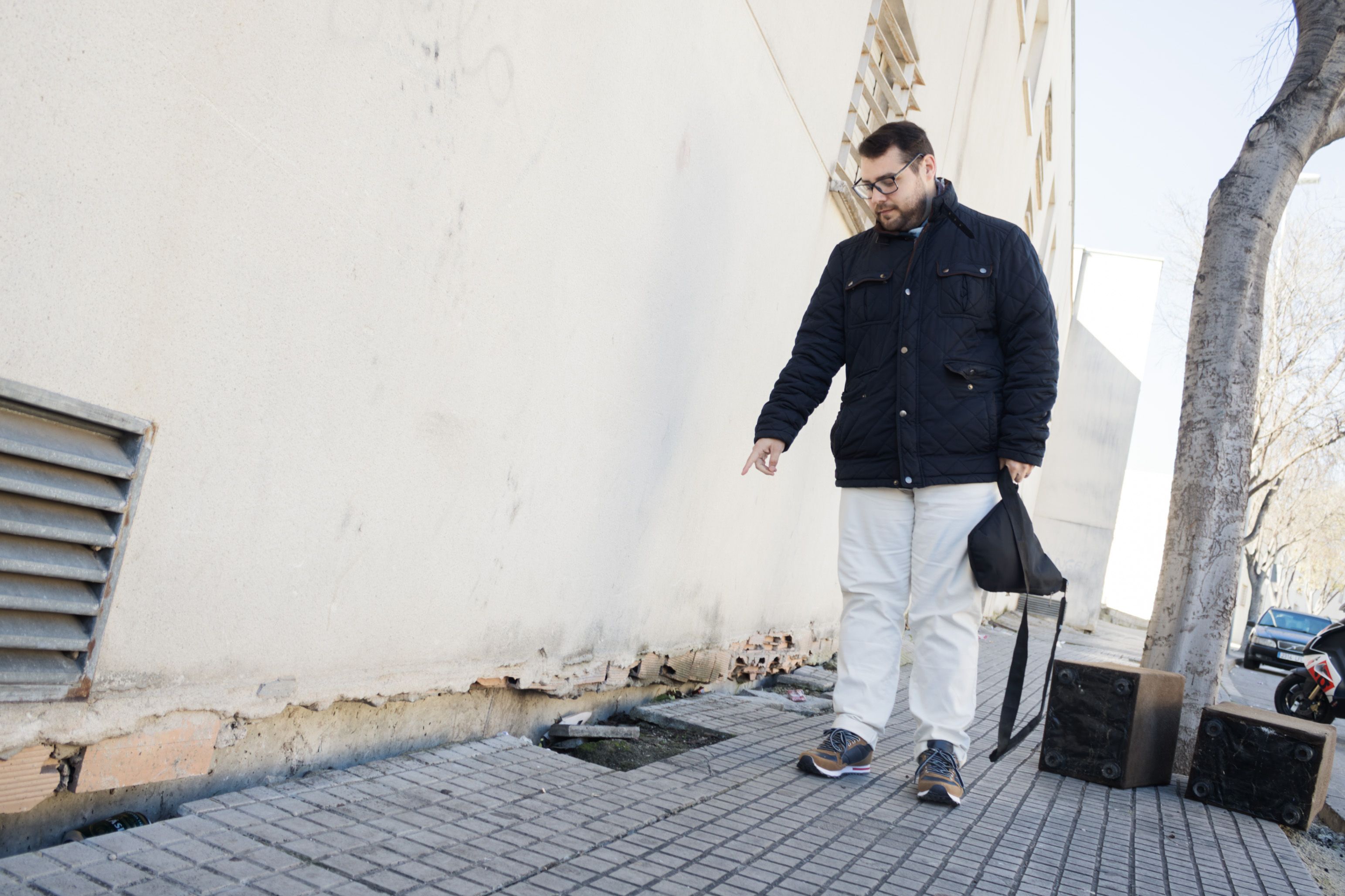 Daniel, uno de los vecinos afectados, muestra las grietas y agujeros de la calle Azorín en la barriada Federico Mayo de Jerez.