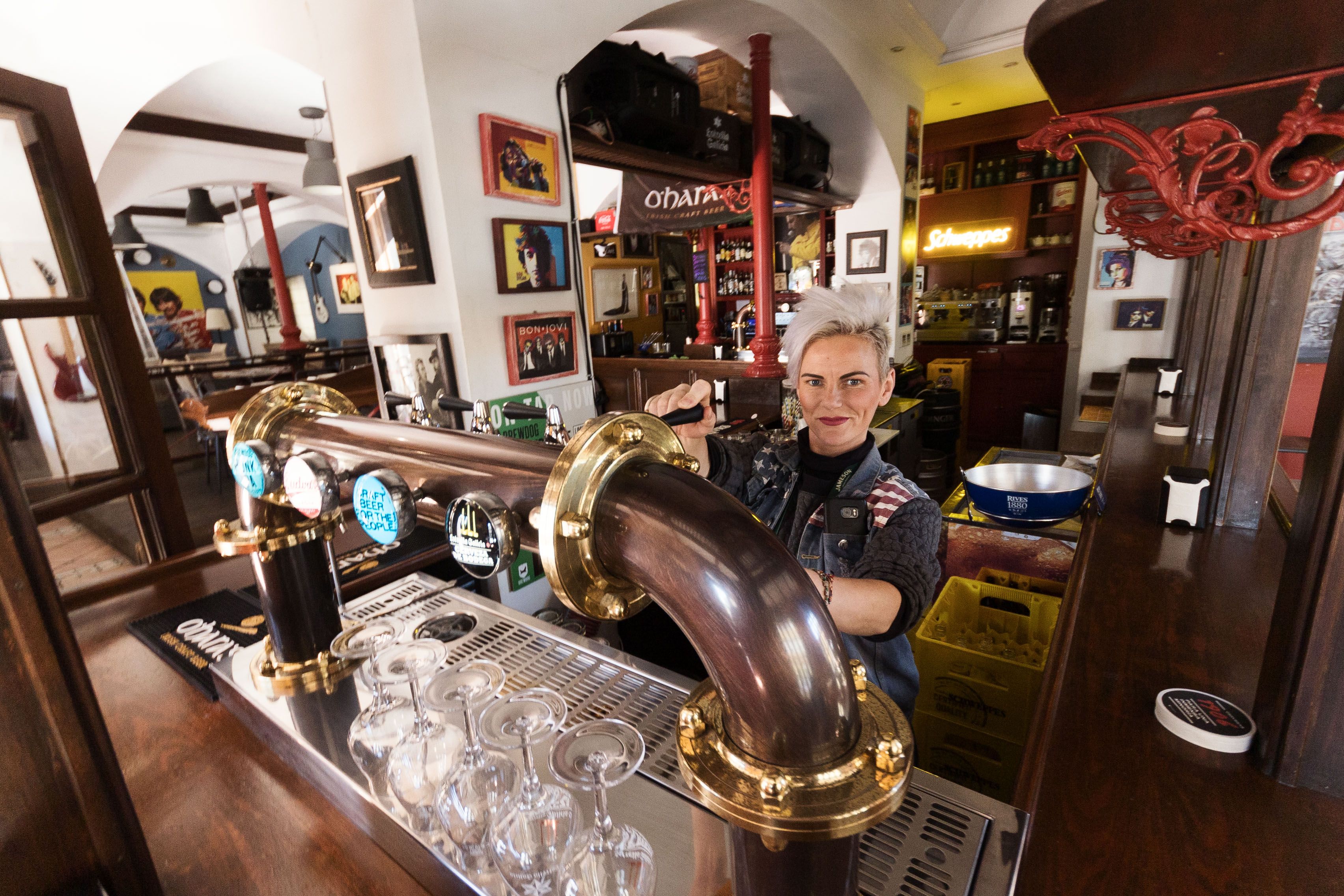 Adela sirve una copa de cerveza de bodega. 