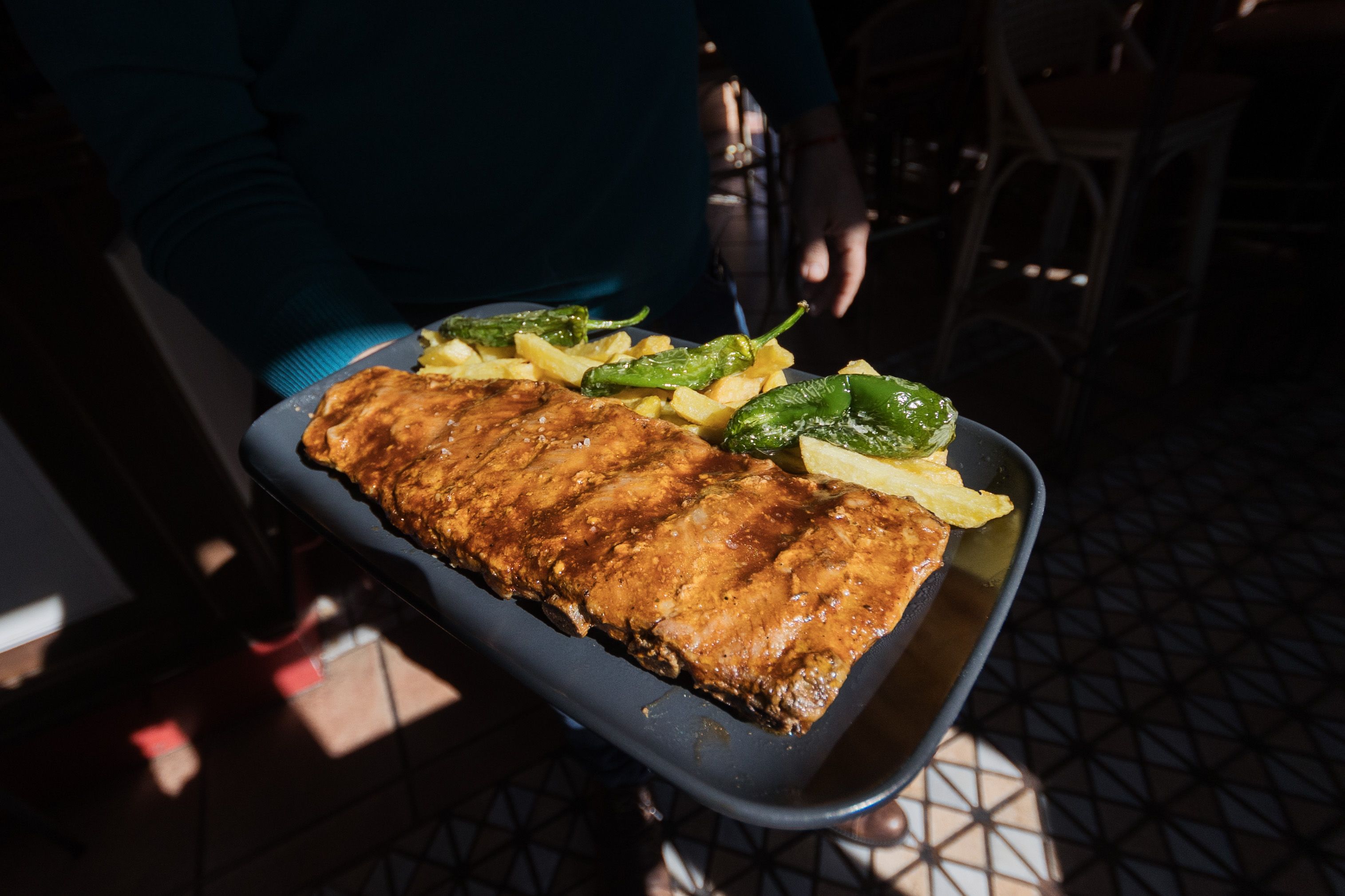 Costillar acompañado de patatas y pimientos. 