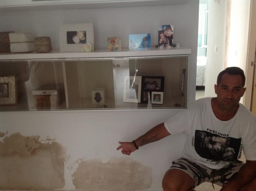 Uno de los vecinos afectados muestra las humedades de la pared de su vivienda, en una imagen de archivo.