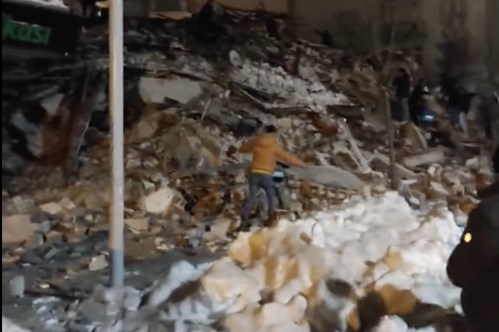 Personas caminan entre los escombros de edificios derrumbados por el terremoto en Turquía. Personas caminan entre los escombros de edificios derrumbados por el terremoto en Turquía.