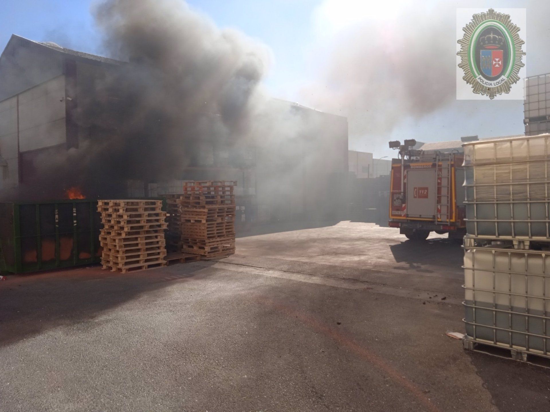 Un policía evita la propagación de un incendio en una empresa de El Viso del Alcor, en Sevilla.