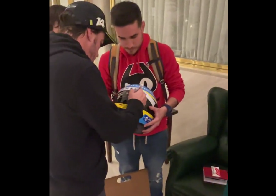 Fernando Alonso firmando el casco de un aficionado en Jerez.