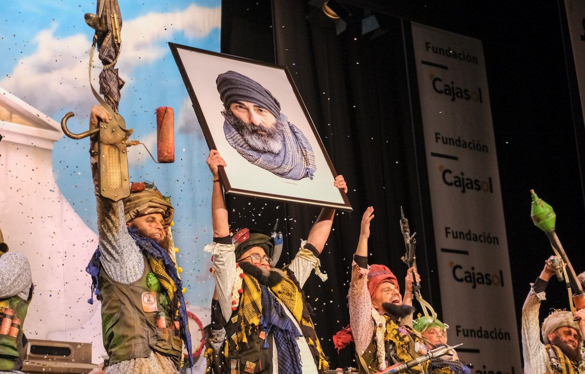 La chirigota 'Frente Talibán de la República Irreverente de Kadikadistán', en el COAC, con publicidad de Fundación Cajasol al fondo. 