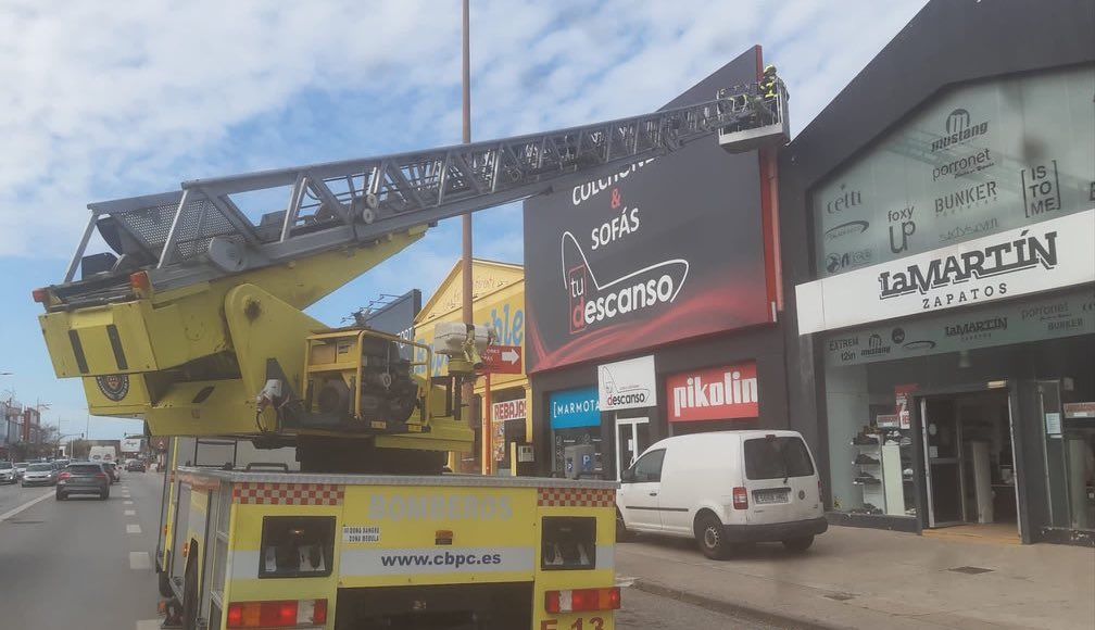 Bomberos asegurando cartelería caída por el viento.