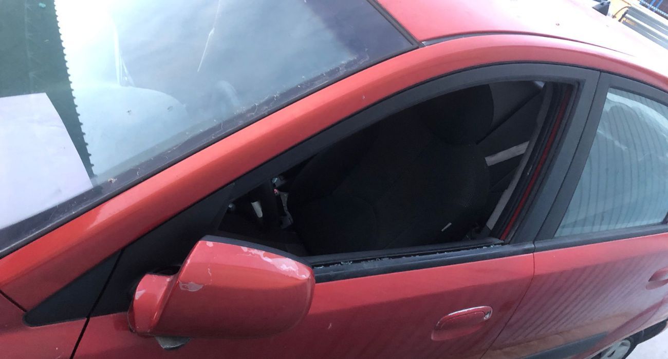 El coche de la trabajadora, con la ventanilla destrozada.