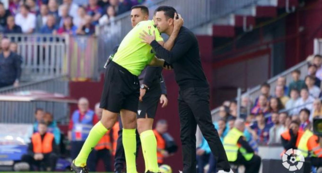El entrenador del Barcelona, Xavi Hernández, abraza a Mateu Lahoz durante un partido.