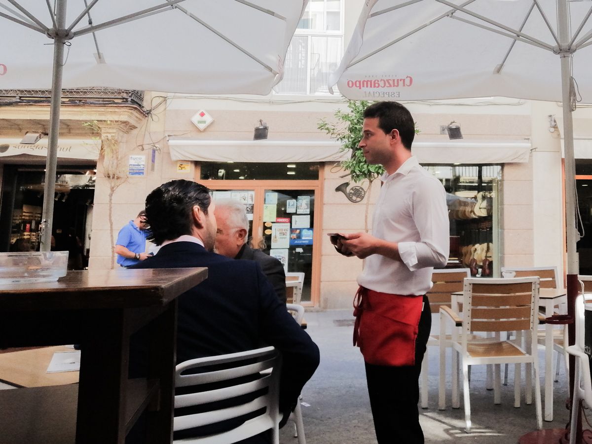 Un camarero atendiendo a un cliente en un restaurante.
