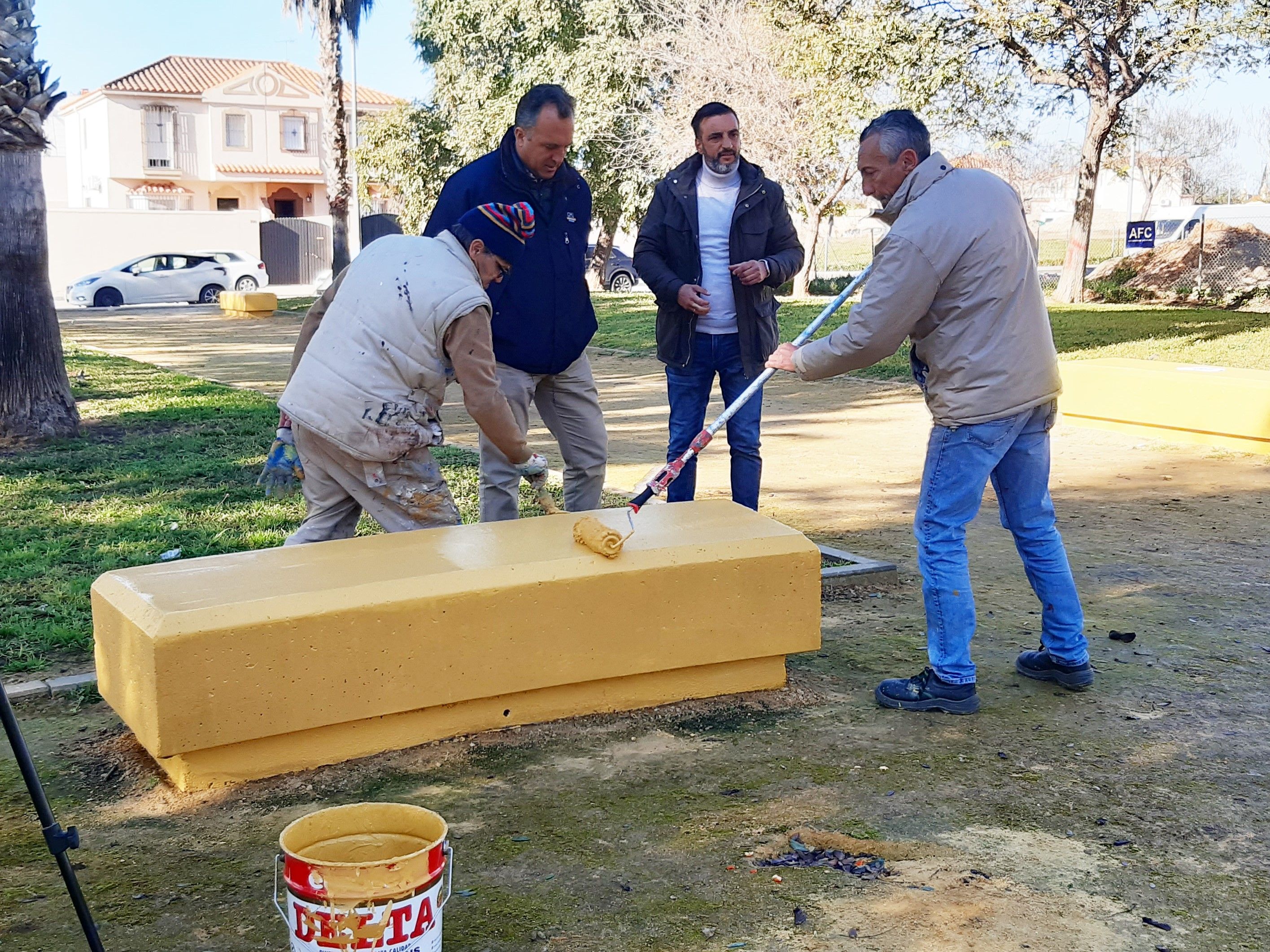 Operarios municipales pintando uno de los bancos de la avenida con la presencia del delegado Diaz.