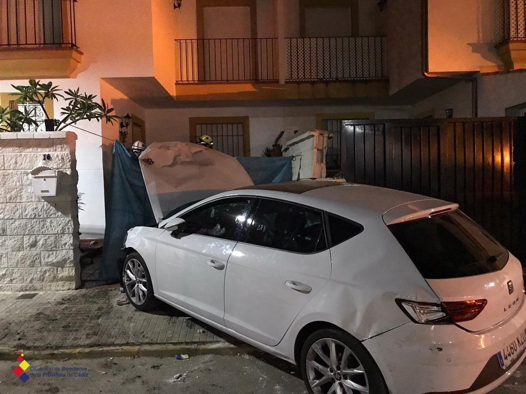 El coche tras colisionar contra la puerta de la vivienda en Castellar.