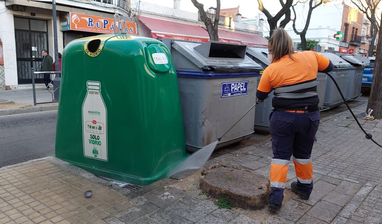 Una mujer limpia un contenedor en Sevilla. El paro vuelve a subir en Andalucía.