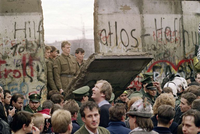 Ciudadanos del Oeste observan cómo guardias de frontera del Este proceden al derribo del muro el 11 de noviembre de 1989 / GERARD MALIE (AFP)