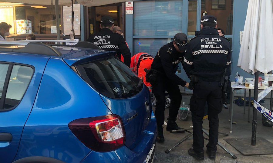 Agentes ayundando al hombre fallecido en Sevilla.