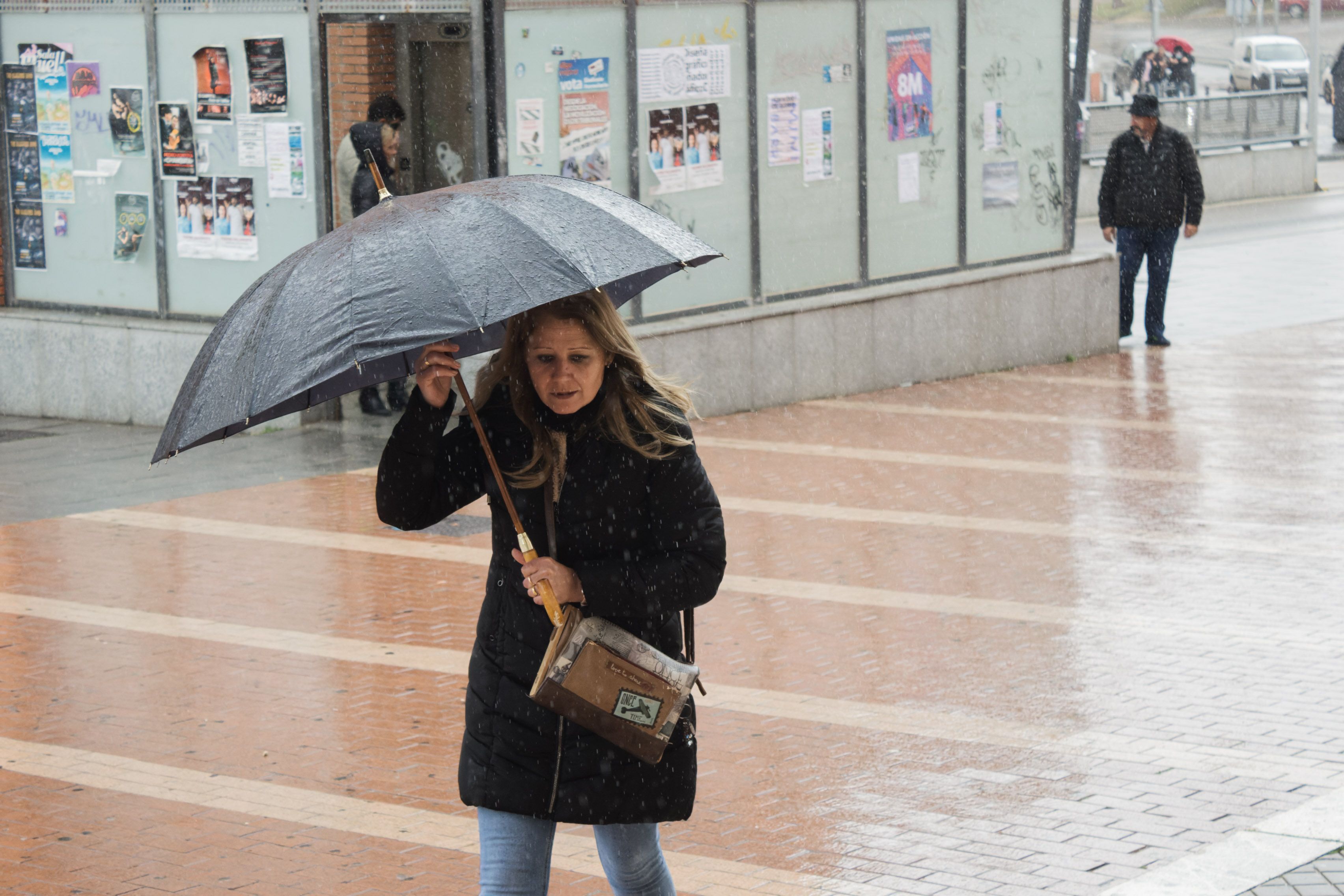 Una persona camina con paraguas en un día lluvioso. 