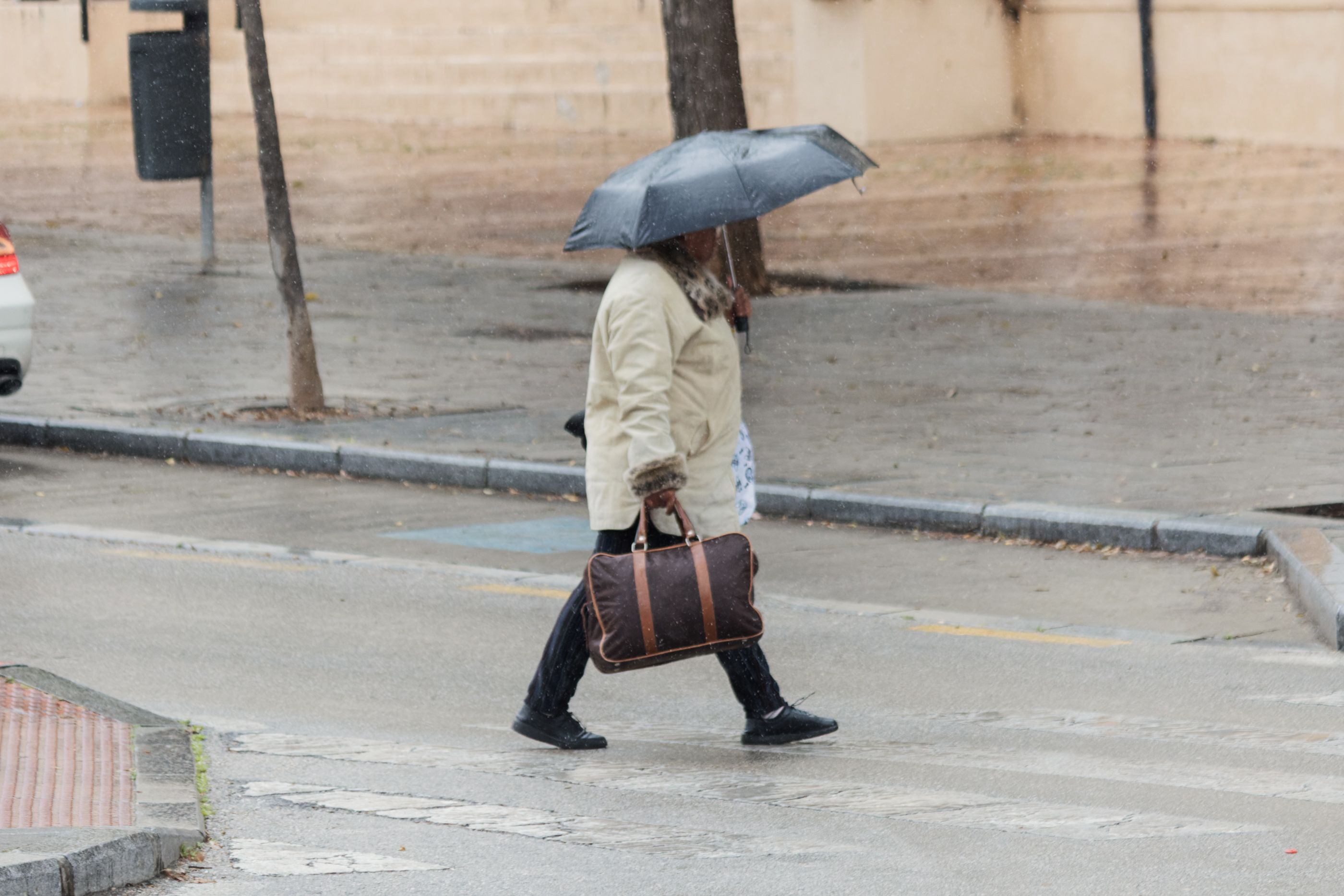 Una persona se refugia de la lluvia en Andalucía en una imagen de archivo.
