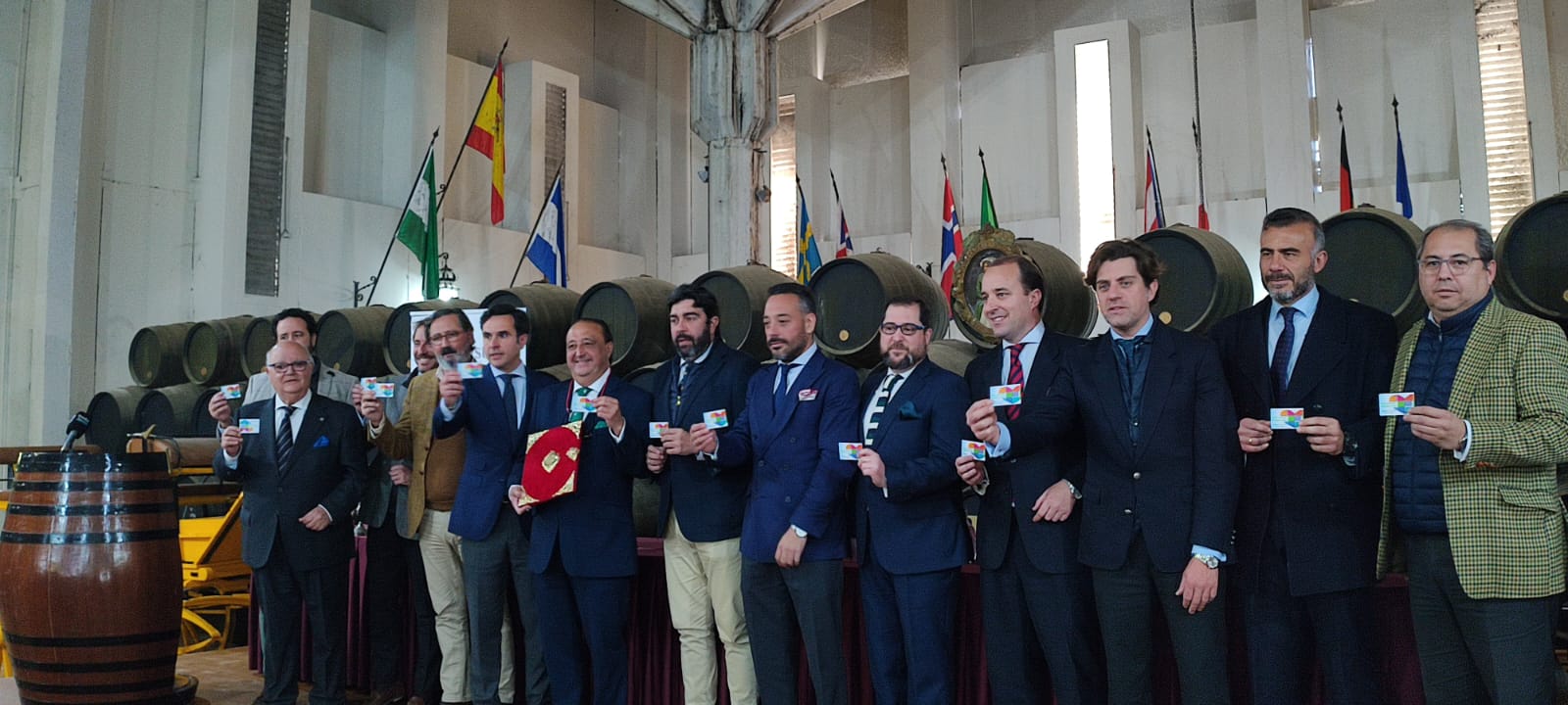 Los integrantes de la tertulia arropando al pregonero, en el centro con las pastas de color rojo, en el acto de entrega.