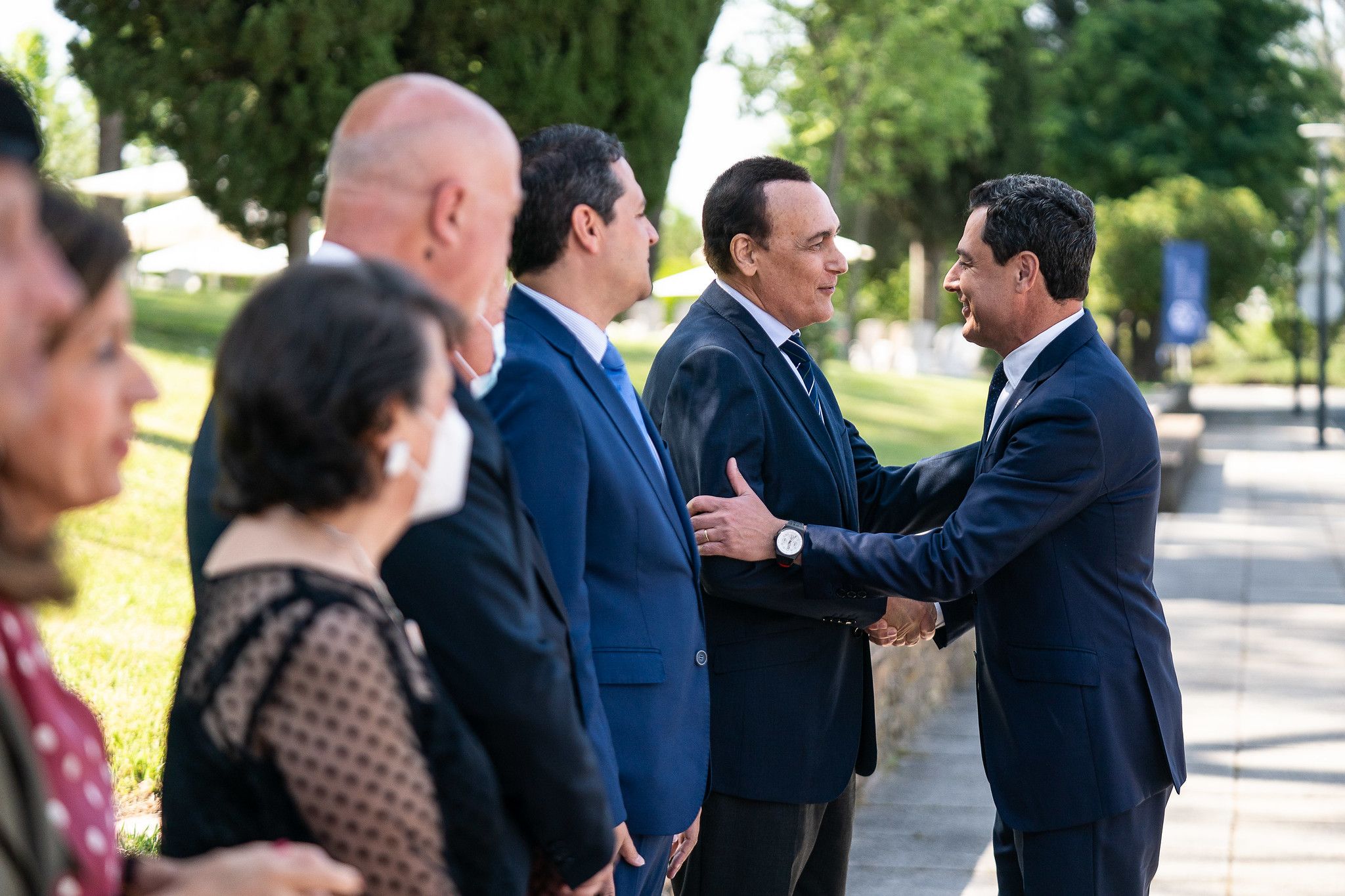 El presidente Moreno saluda al consejero Villamandos en un acto por el 50 aniversario de la Universidad de Córdoba.