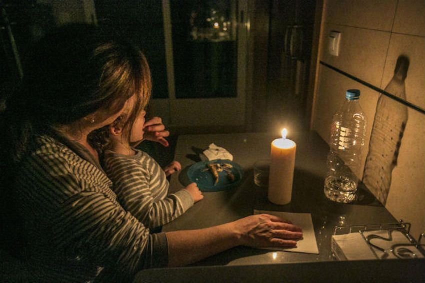 Una familia, a la luz de una vela durante la noche.