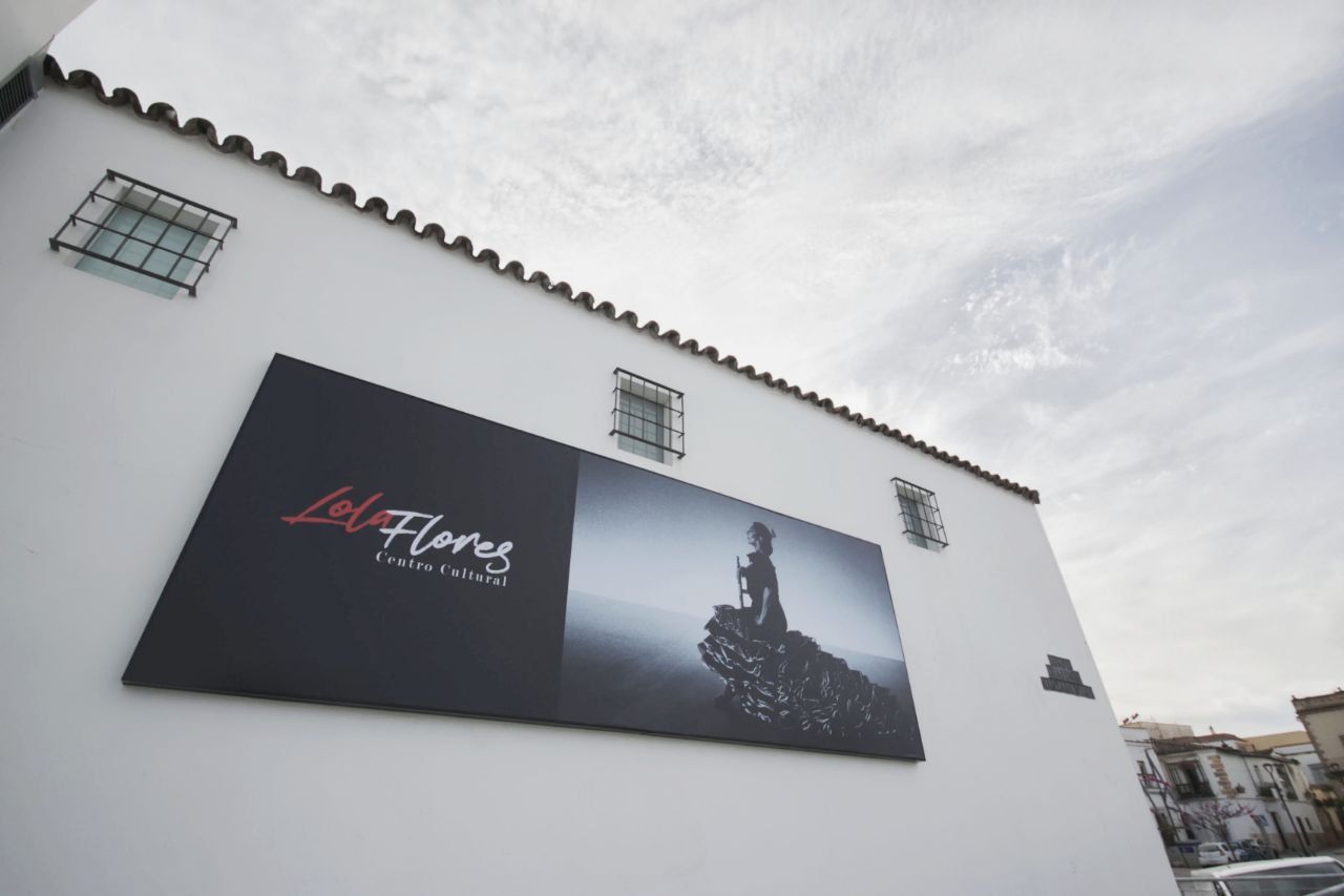 Acceso principal de la Nave del Aceite, sede permanente del Centro Cultural Lola Flores, con la icónica foto de 'Flamenco', de Carlos Saura.