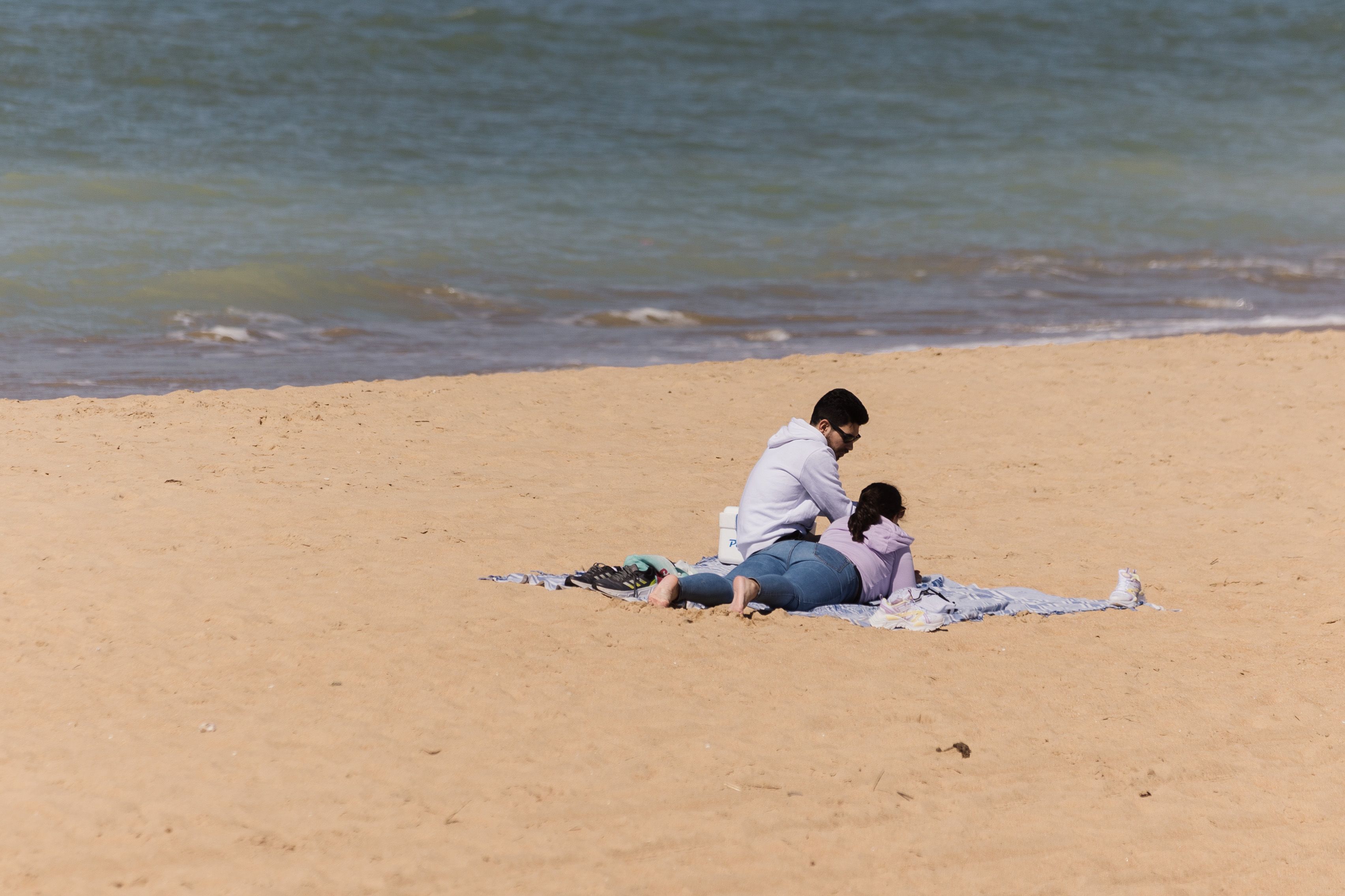 Una pareja en una playa de Chipiona en una imagen de archivo.