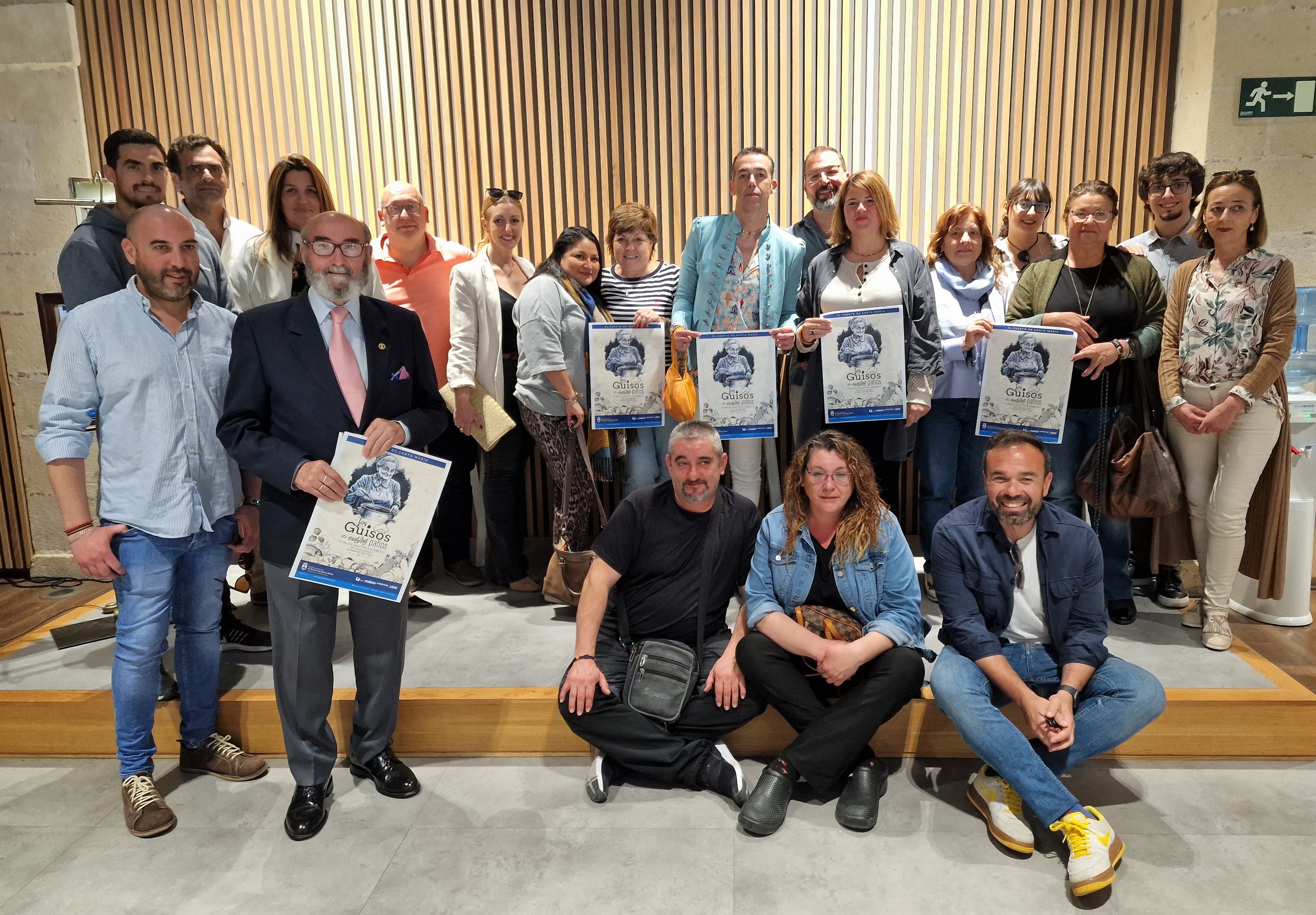Imagen de grupo en la presentación de la ruta gastronómica mostrando el cartel promocional.