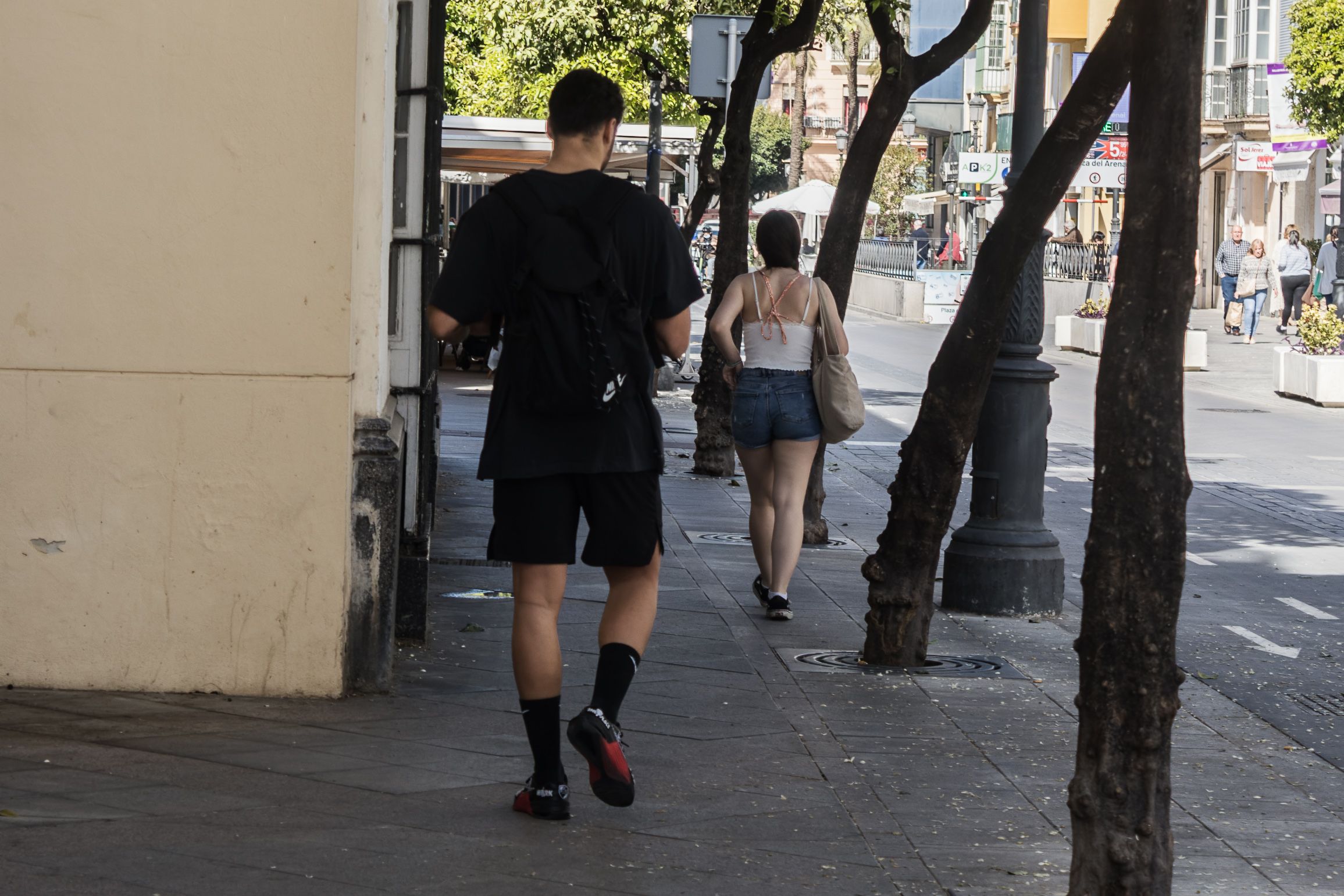 Dos personas pasean en una ciudad andaluza. 
