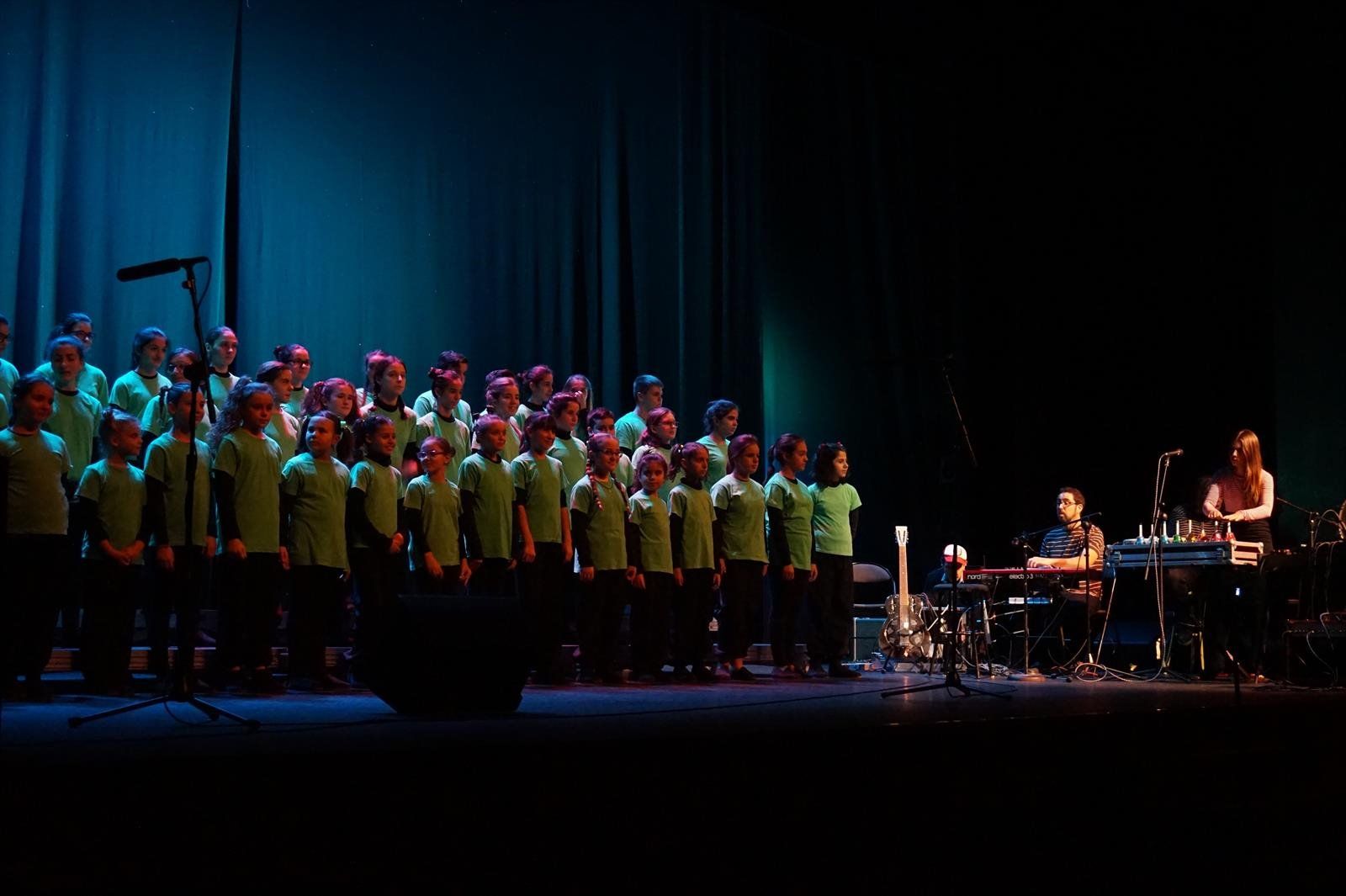 Los niños de la Escuela Coral Jardín de Menesteo se funden con la música potente de Los Jaguares de la Bahía.