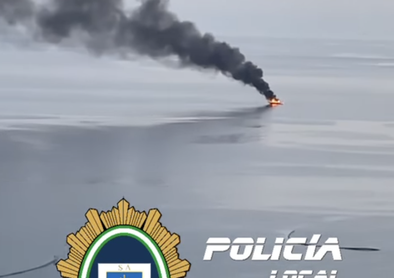 En la imagen de la Policía Local de Salobreña, la embarcación ardiendo frente a la costa.
