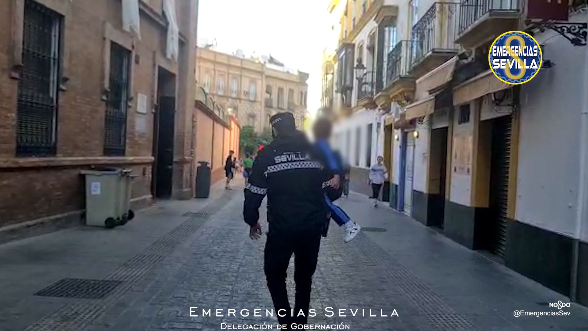 El policía llevando al niño.