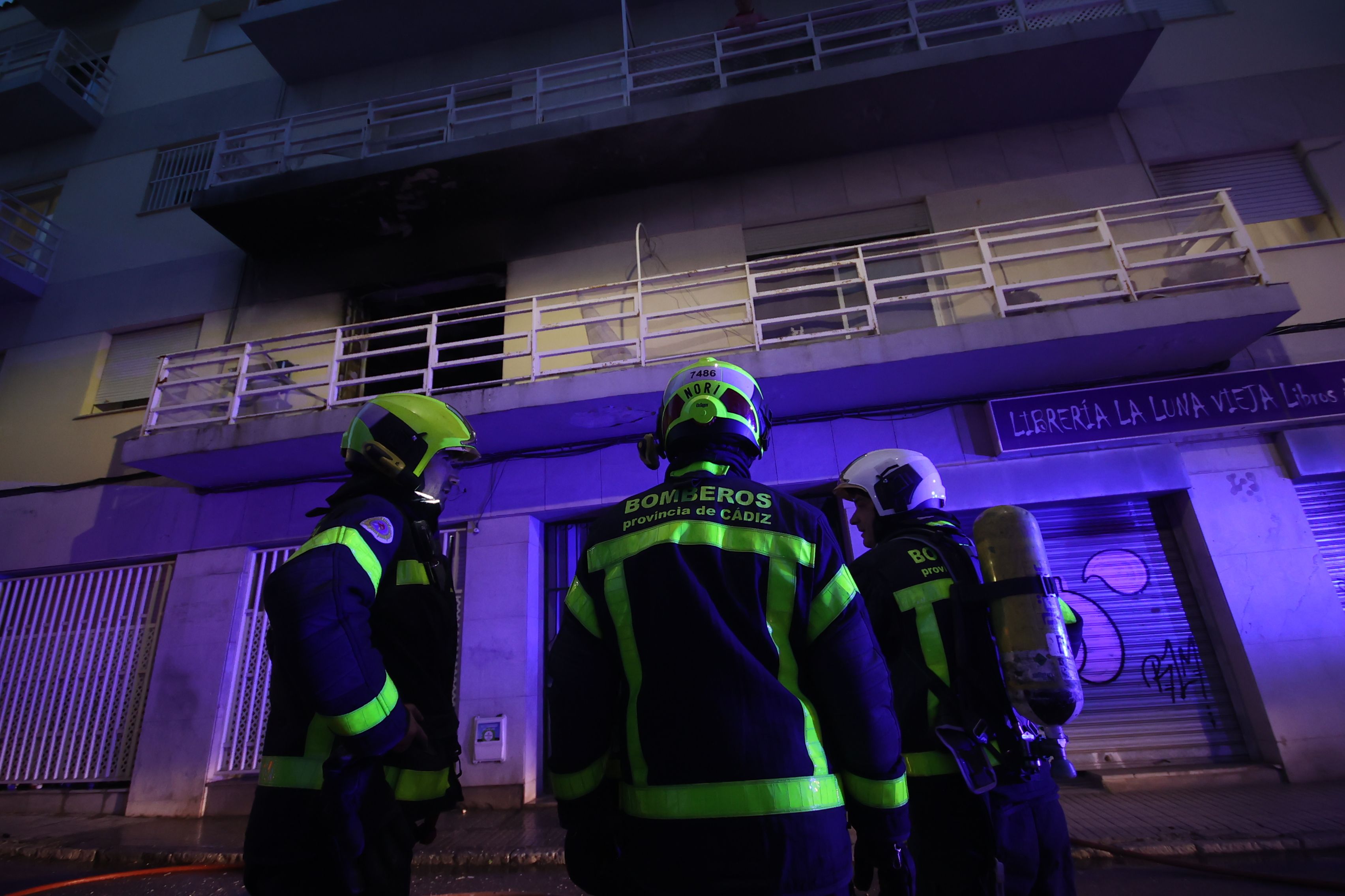 Bomberos, a la entrada del bloque donde ha tenido lugar el fuego.   MANU GARCÍA