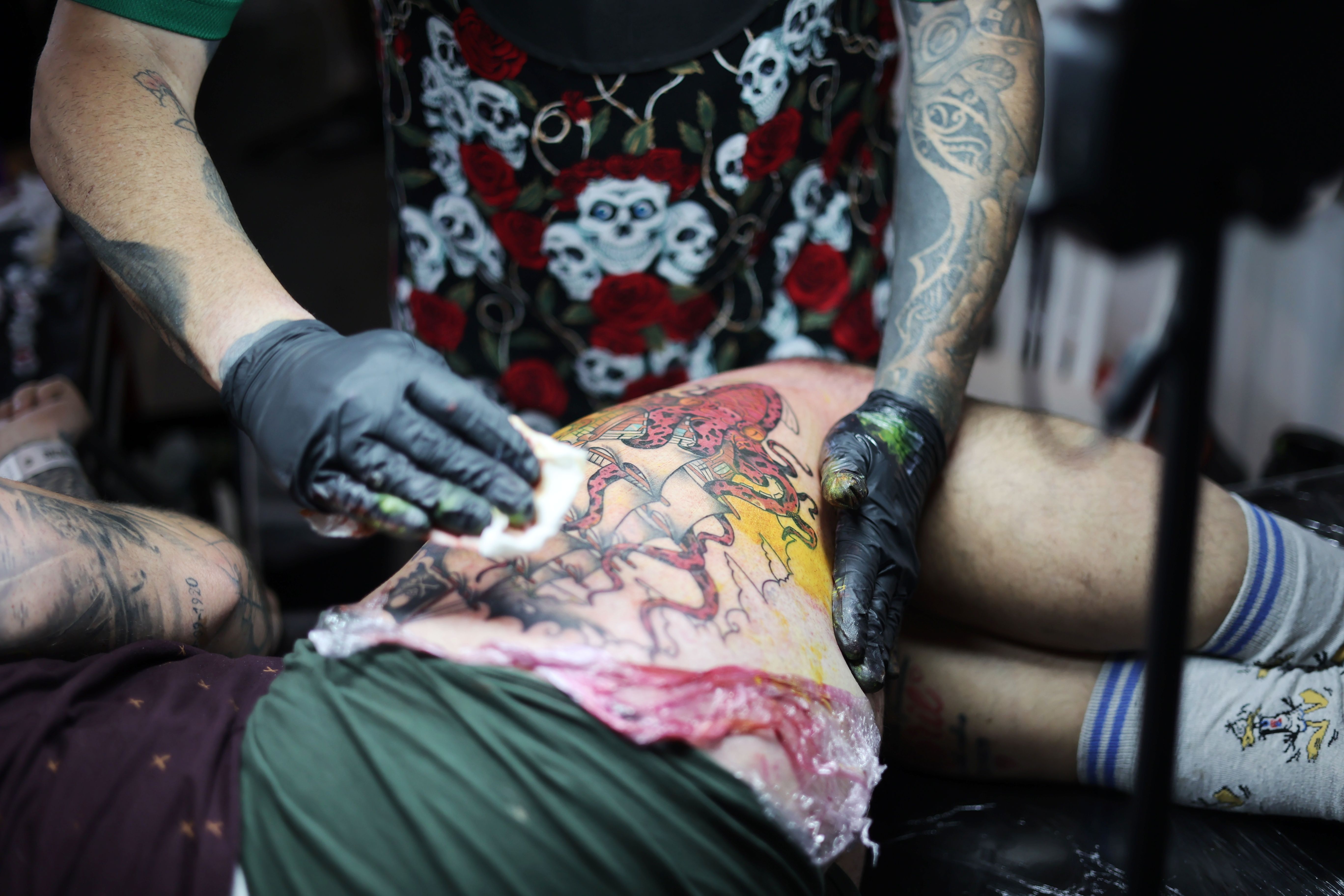 Un tatuador haciendo un tatuaje a una persona. Un tatuador haciendo un tatuaje a una persona.