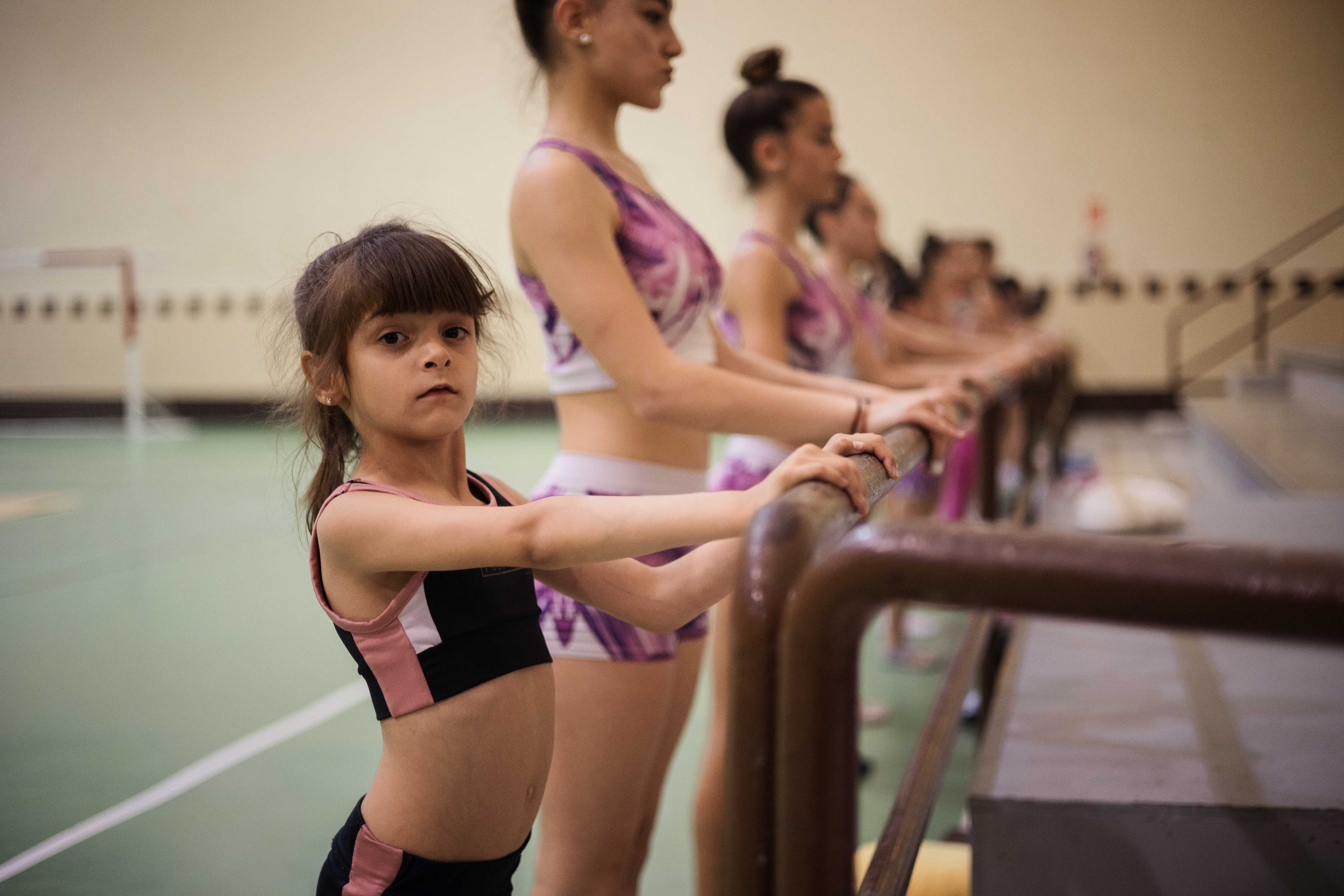 Las niñas realizan ejercicios en la barra. 