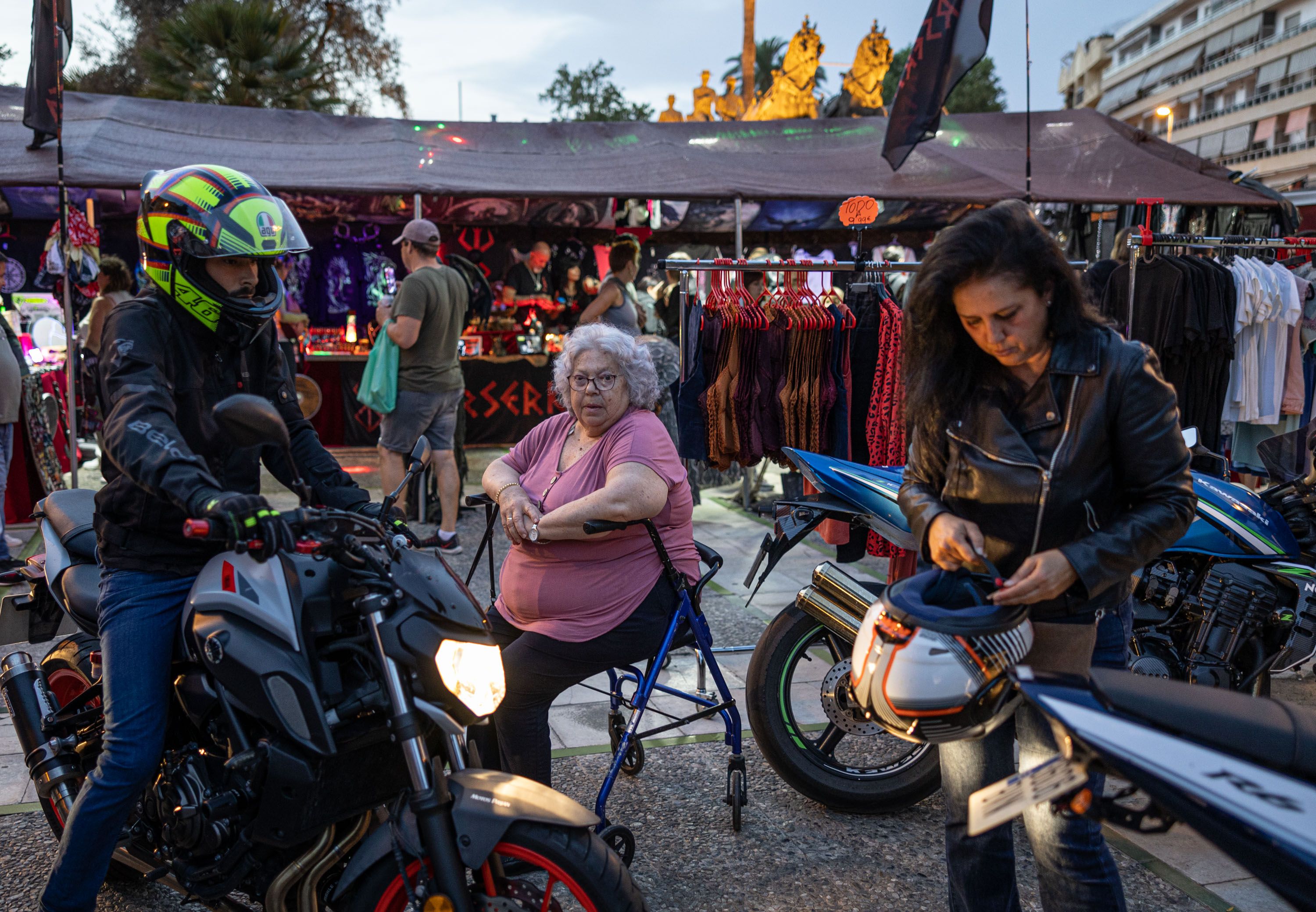 Dos moteros se preparan para salir, junto a una mujer que descansa en su andador, durante la motorada. Dos moteros se preparan para salir, junto a una mujer que descansa en su andador, durante la motorada.
