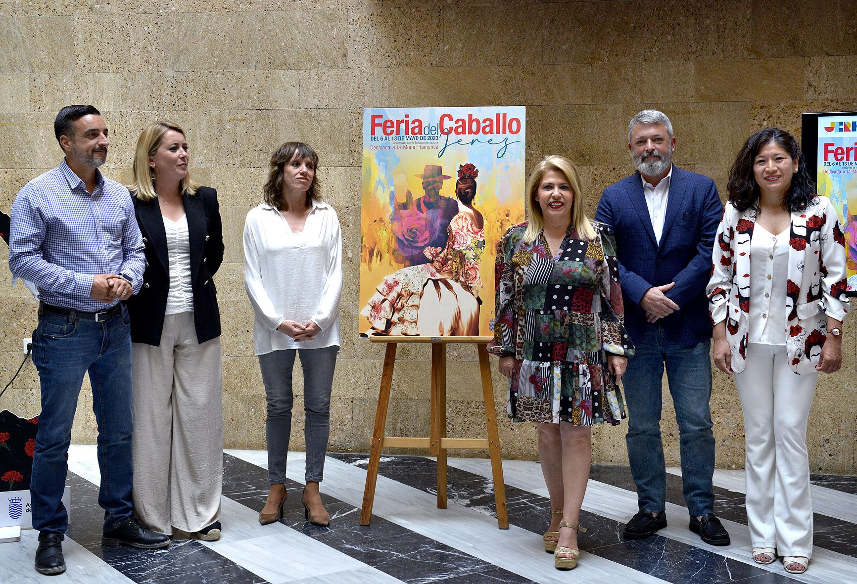 La alcaldesa y delegados posando junto al cartel de la Feria del Caballo en el Ayuntamiento. 