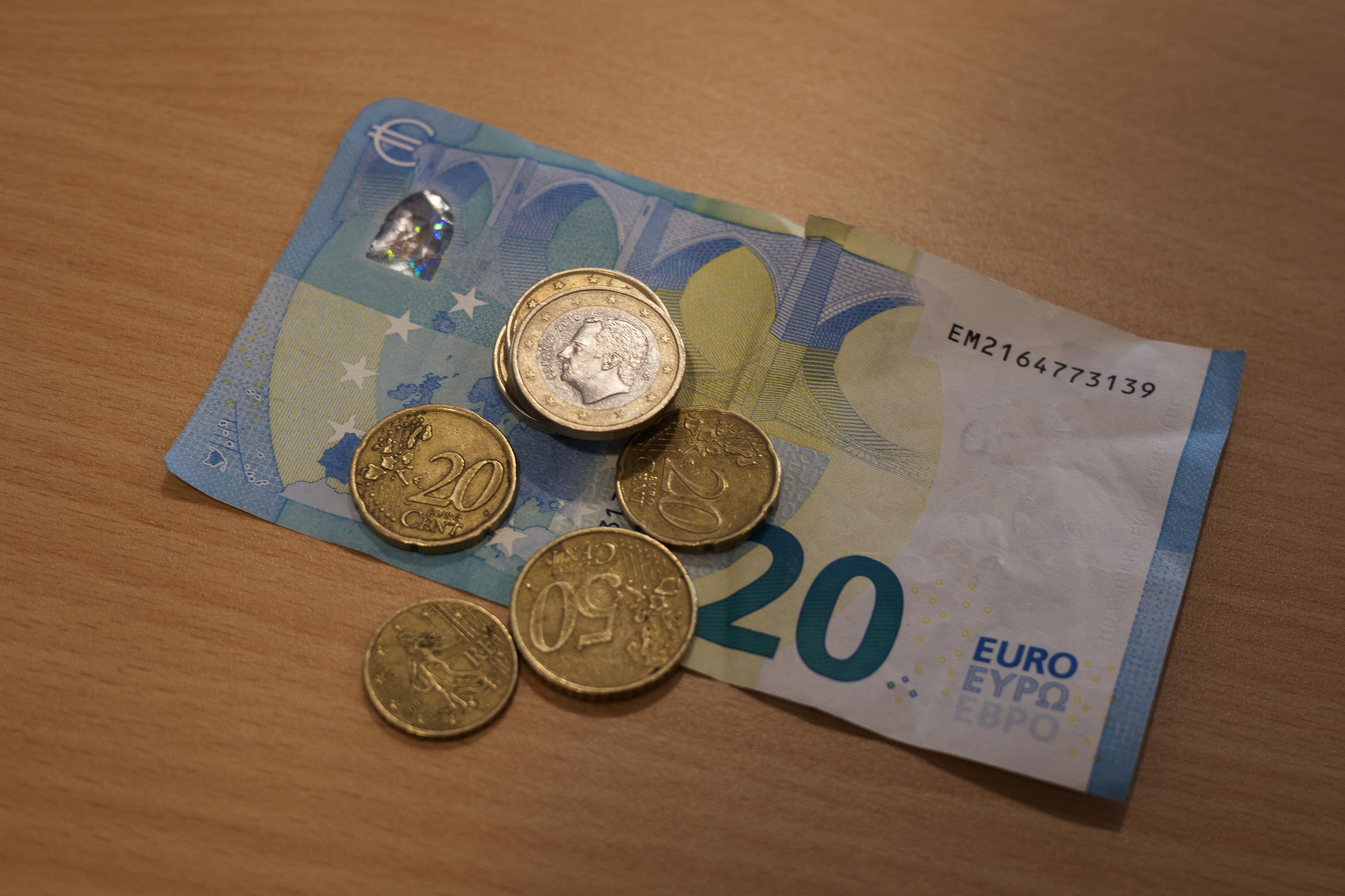 Un billete de veinte euros y unas monedas.