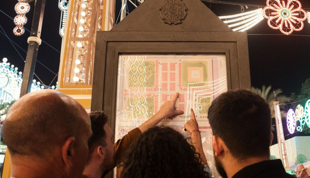 Personas mirando los mapas de la Feria de Jerez.