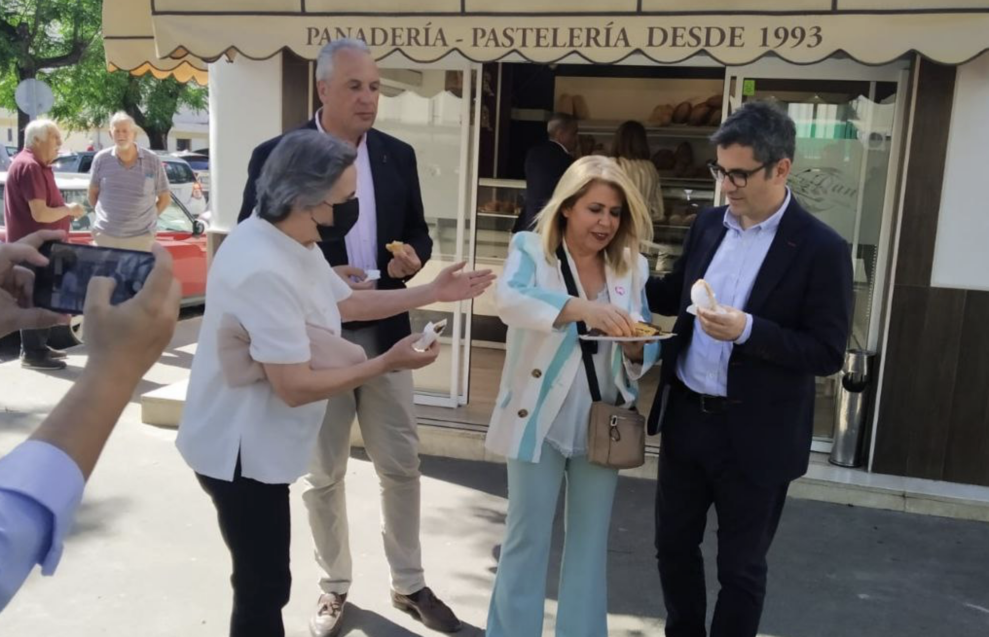 Mamen Sánchez comparte pasteles con el ministro Bolaños, ante la mirada del presidente de Diputación, Juan Carlos Ruiz Boix.