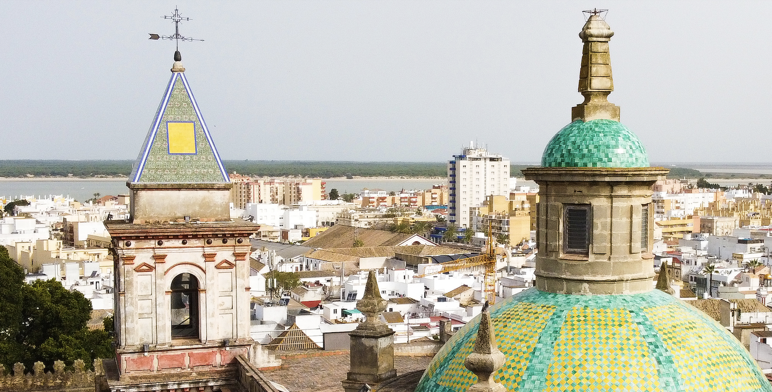 Panorámica de Sanlúcar con la cúpula de la Merced y, al fondo, la costa y Doñana.