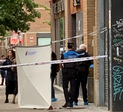 Agentes policiales a la entrada del bloque donde una mujer ha matado a su expareja.