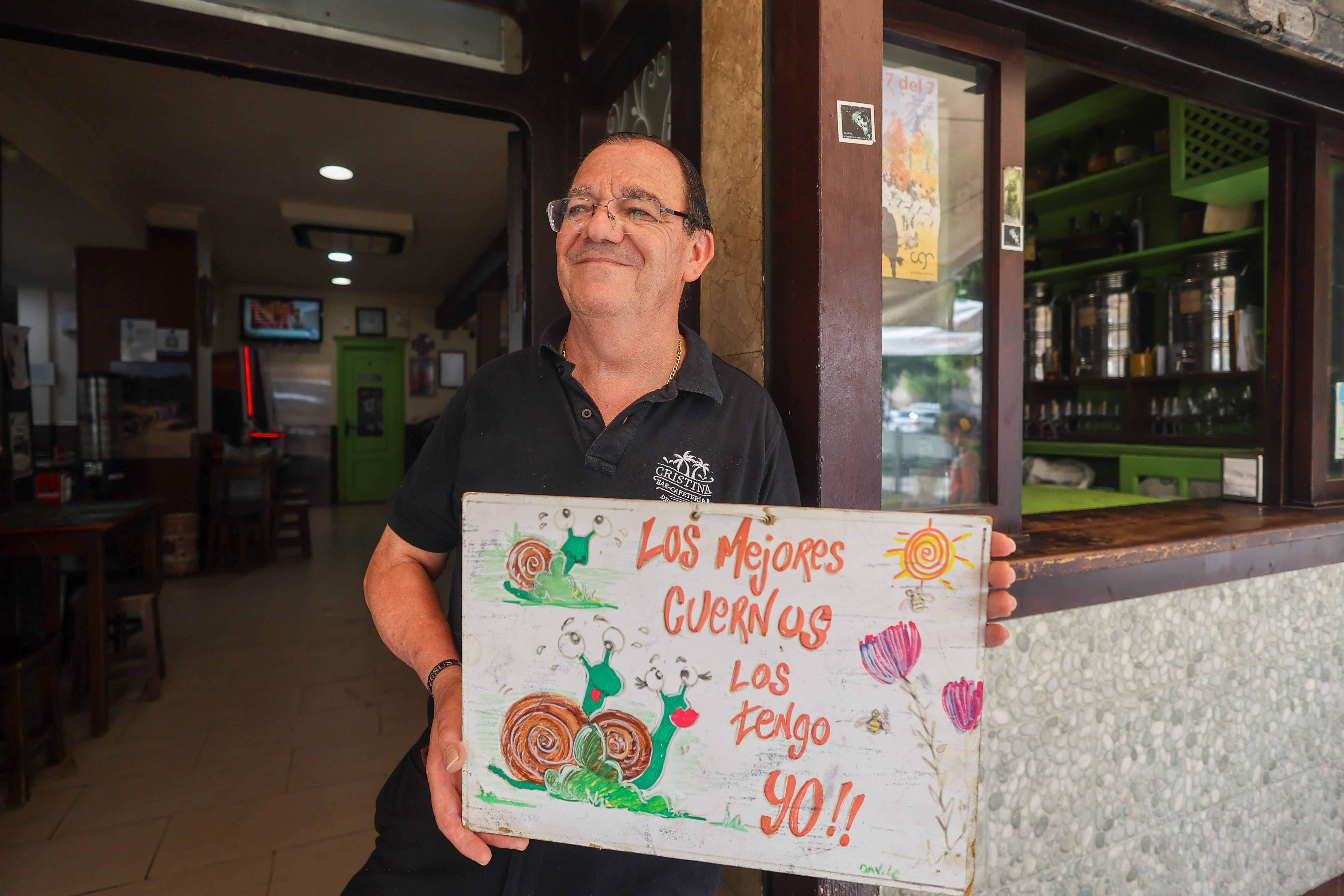 Fernando Vivero con el simpático cartel 'caracolero' que ahora de ve en el bar.