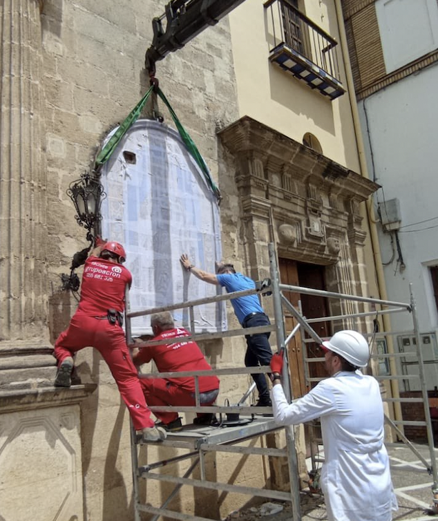 El retablo en el momento de retirarlo de la fachada con la ayuda de una grúa y varios operarios. 