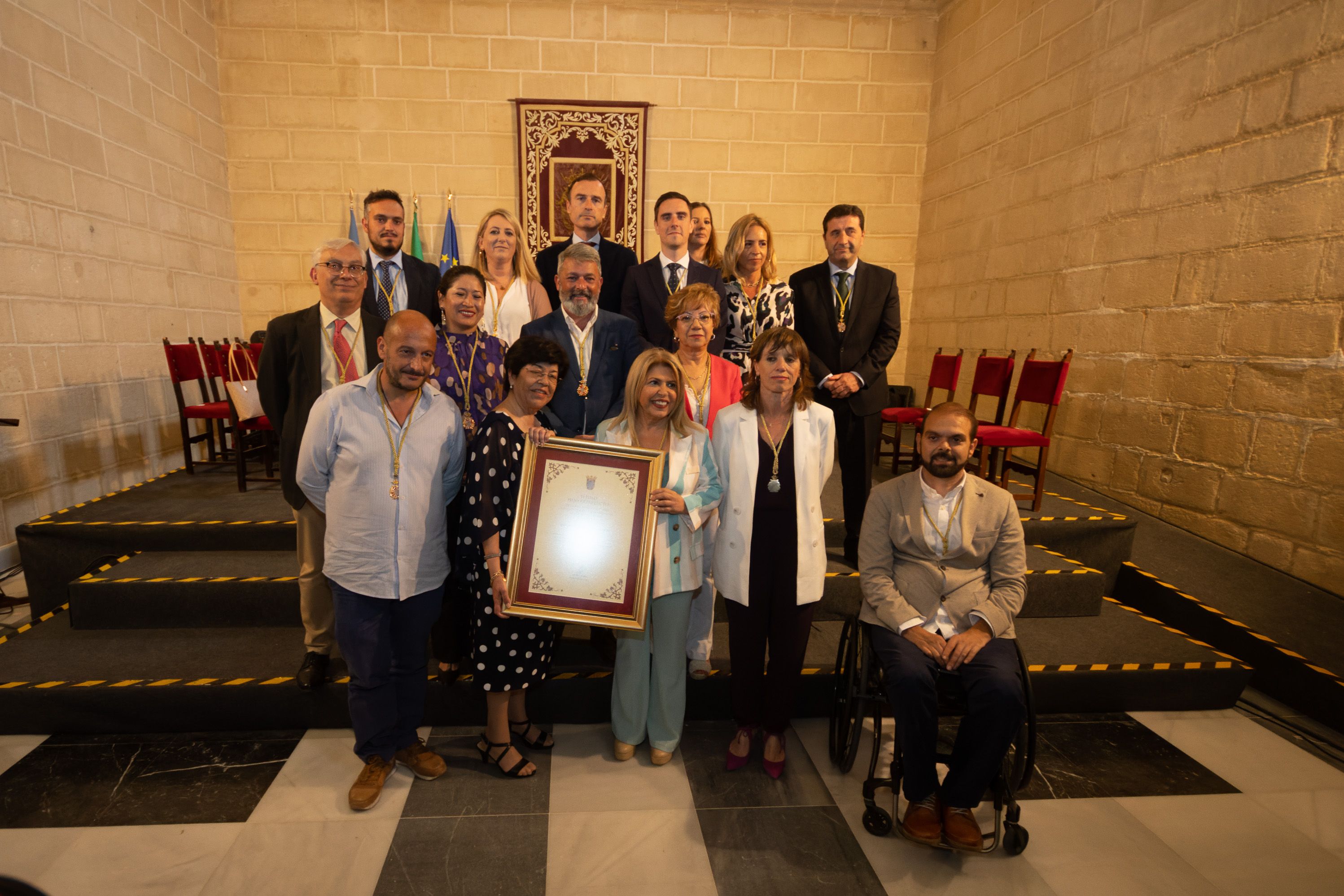 La viuda de Pepe Carrión, con la patente, junto a la alcaldesa y rodeadas de miembros de la Corporación municipal.