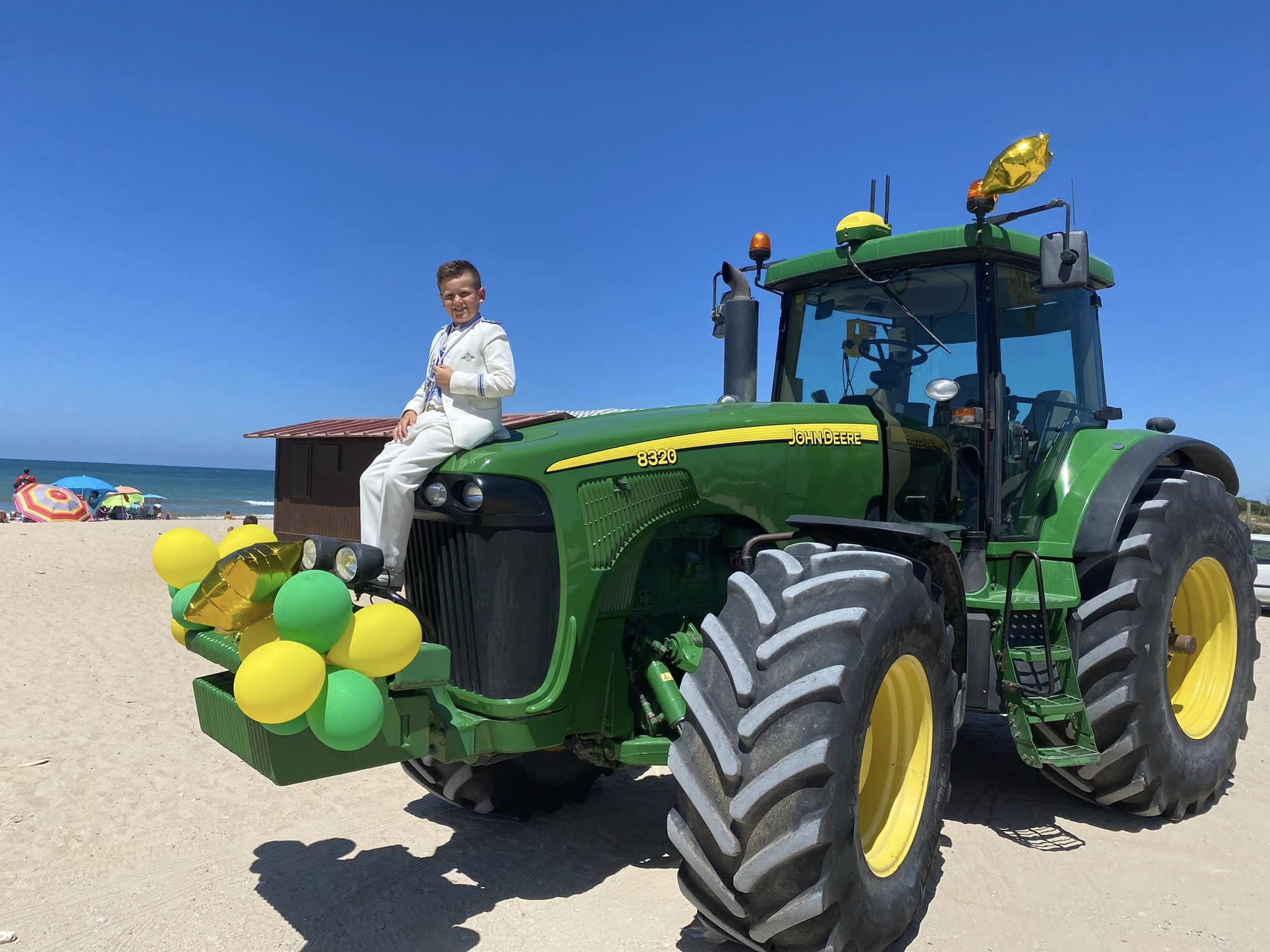 Raúl, con el traje de su Primera Comunión, encima del tractor. 