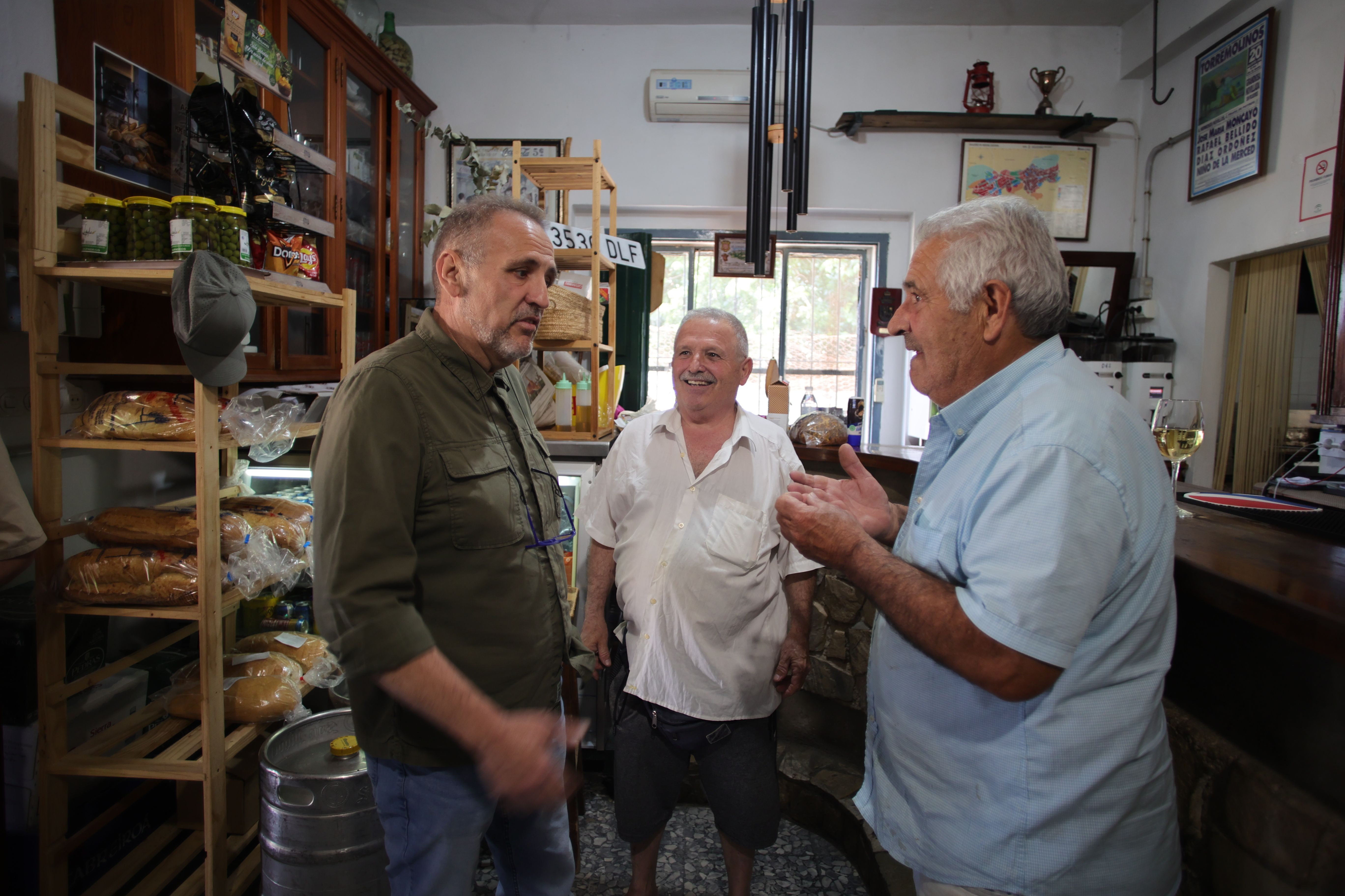 El nuevo alcalde (izquierda), José Manuel Ruiz, de IU, conversa con dos vecinos en la Venta El Soldao durante la campaña electoral.